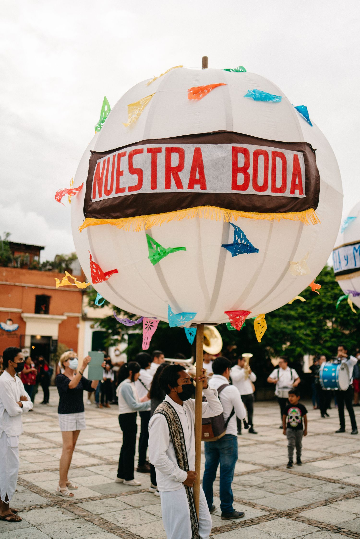 Large white balloon with colorful decorations and Spanish text displayed at outdoor event.