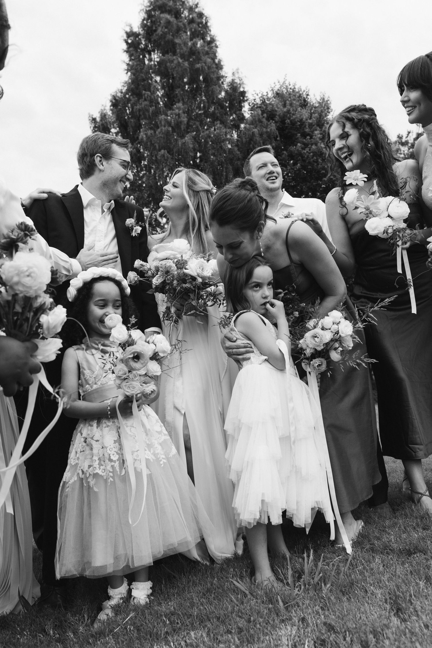 Black and white photo of wedding party with flower girls and bouquets.