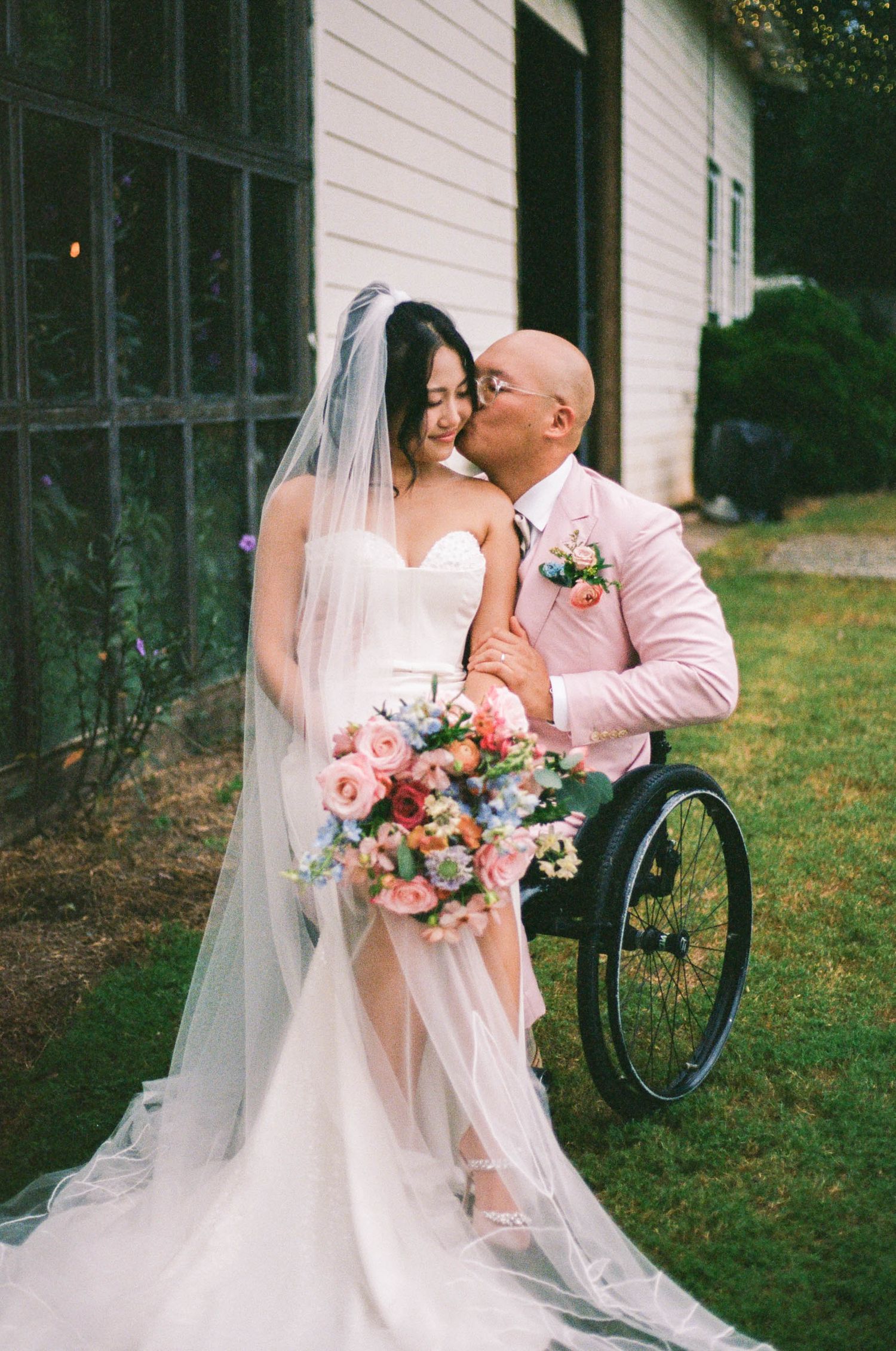 A touching wedding portrait featuring a couple with a beautiful floral bouquet in a garden setting.