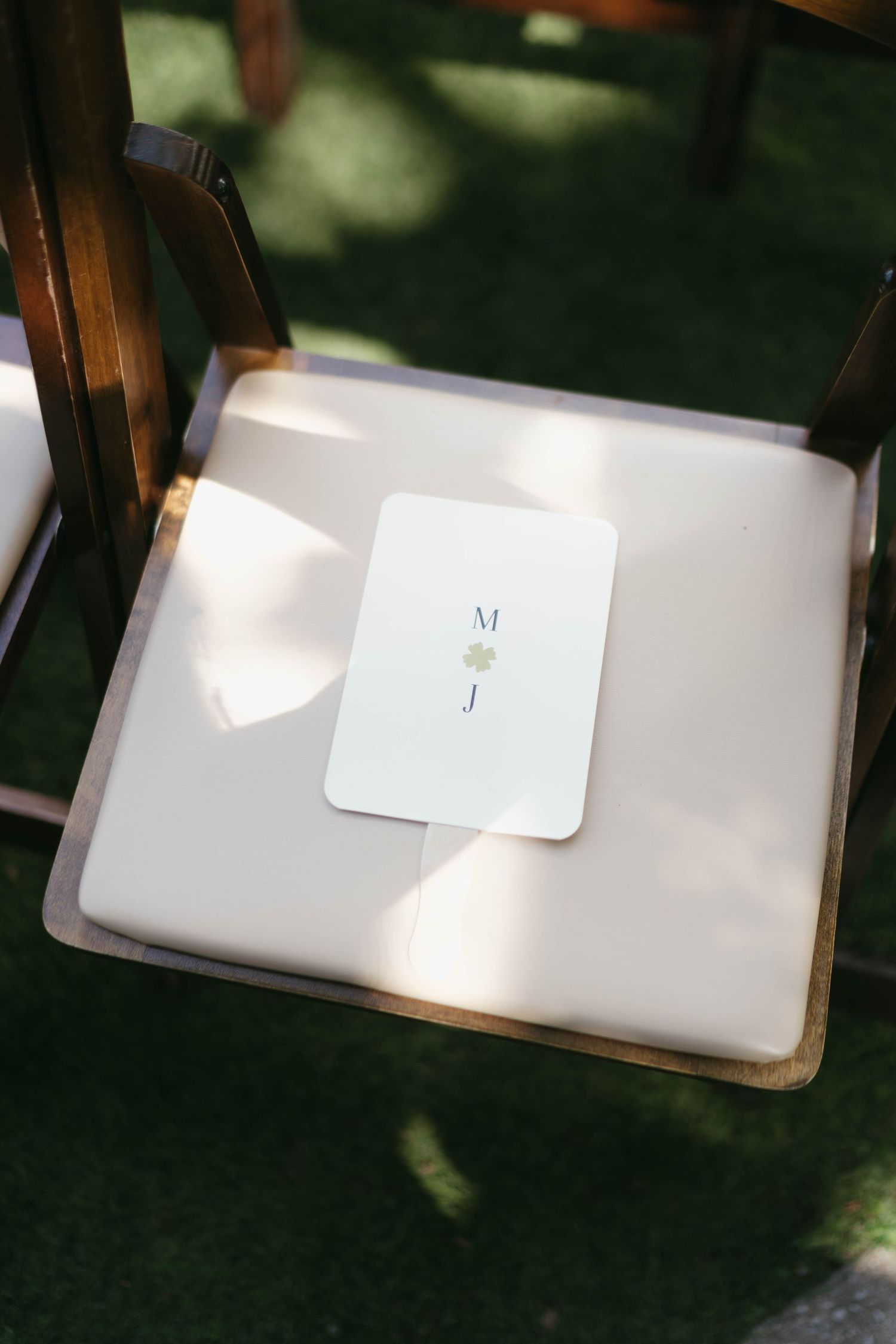 Simple white place cards with initials displayed on a dark surface.