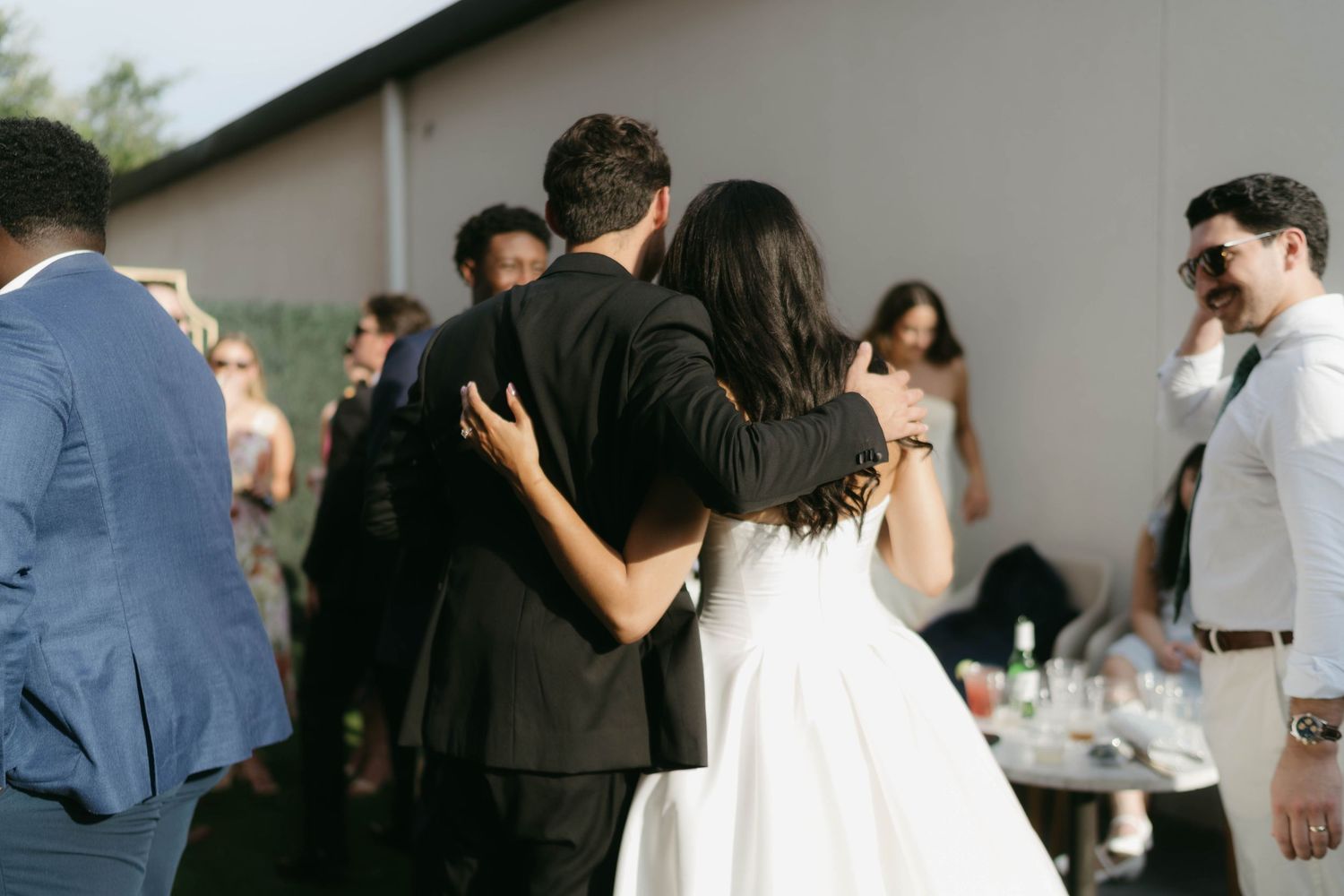 Wedding guests mingling at an outdoor reception with casual atmosphere.
