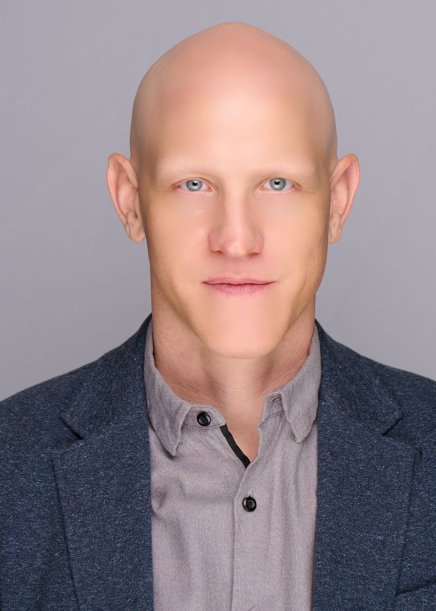 Professional headshots of person in dark blazer and gray shirt against neutral background.