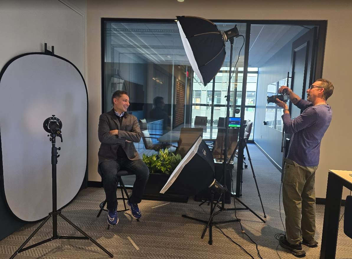 Behind the scenes view of a photography studio with lighting equipment and backdrop setup.