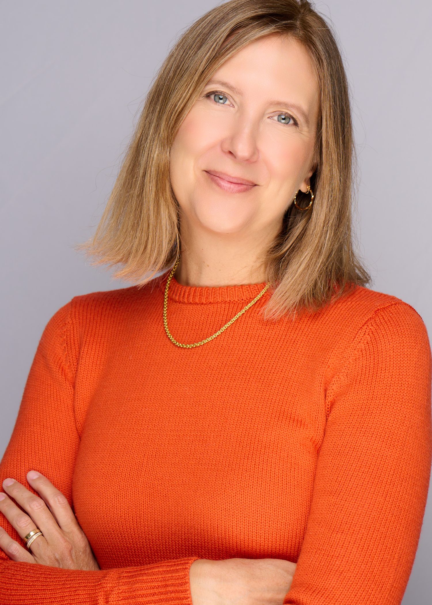 Series of portraits featuring bright orange sweater and casual poses against gray backdrop.
