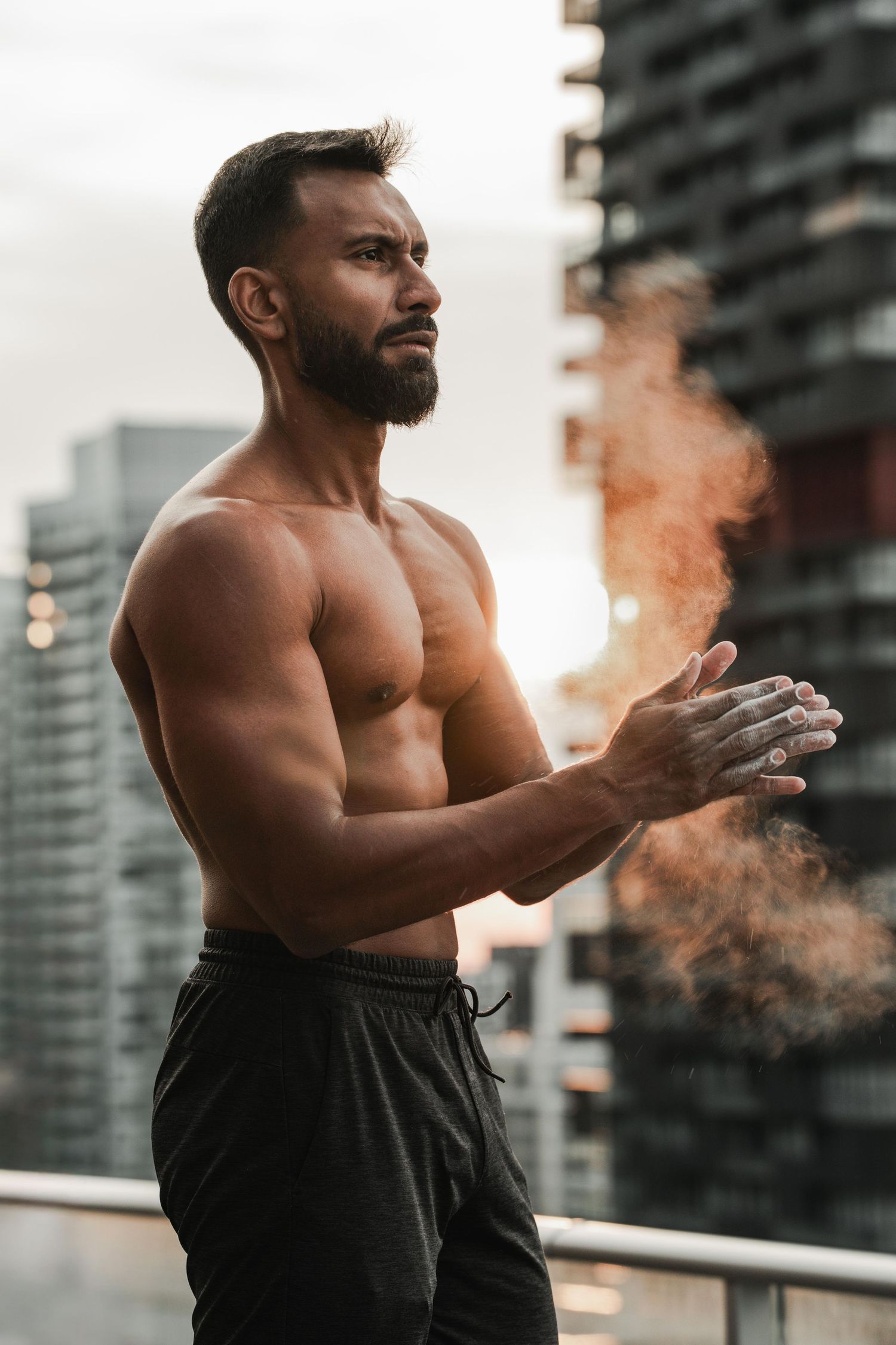 Fitness portrait of muscular man on rooftop overlooking downtown Toronto