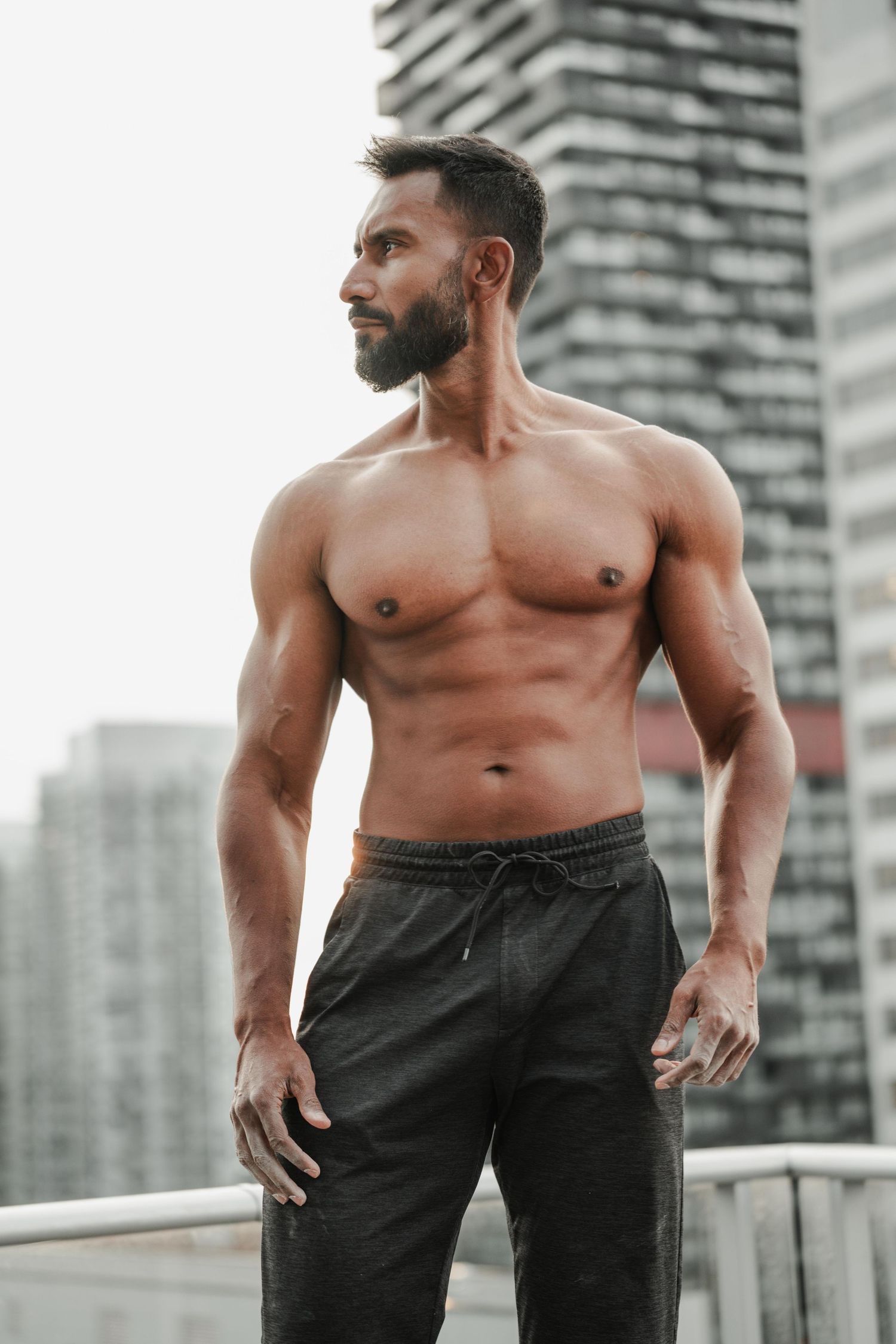 Fitness portrait of muscular man on rooftop overlooking downtown Toronto
