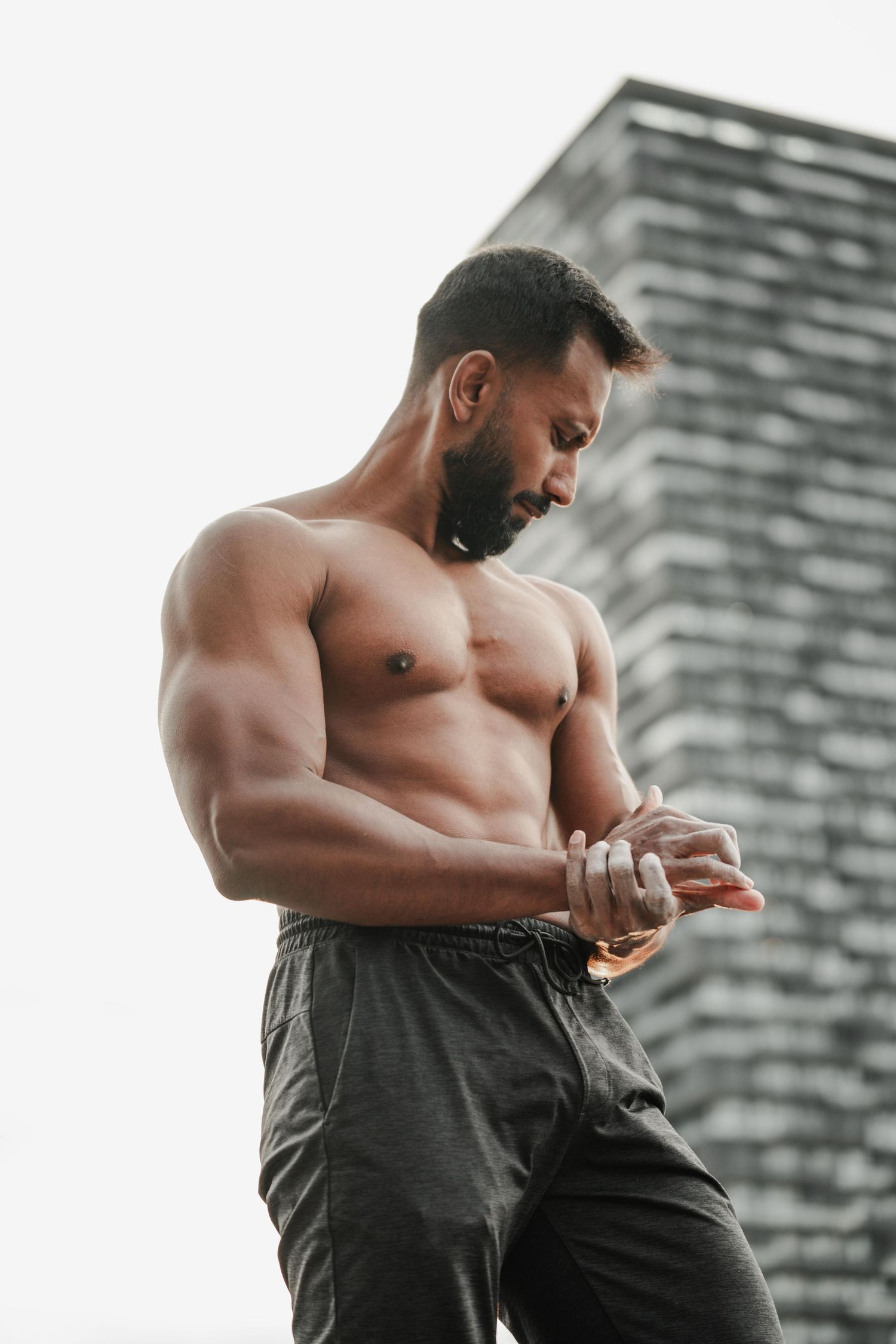 Fitness portrait of muscular man on rooftop overlooking downtown Toronto