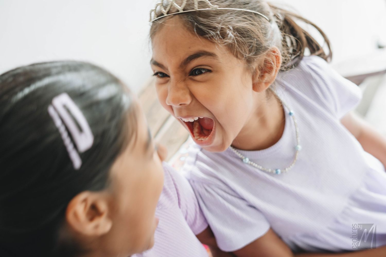 Candid moment of two little sisters laughing together