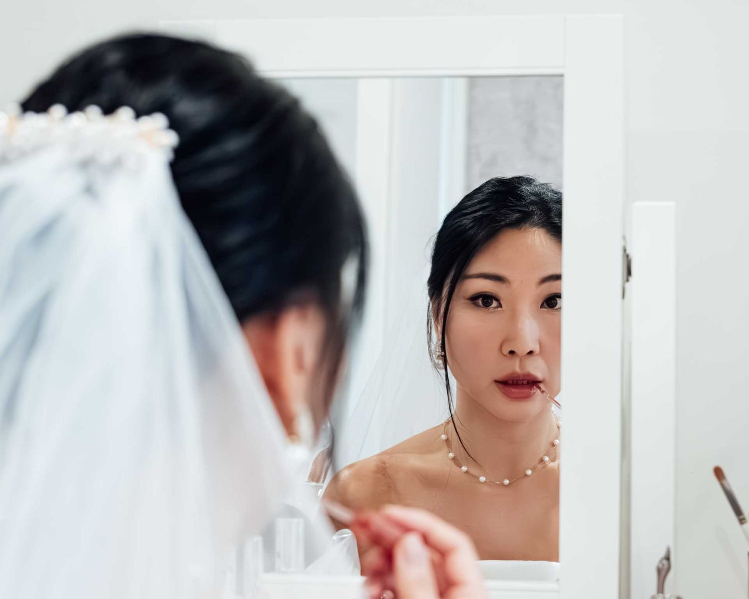 Bride putting on her makeup in the mirror before her wedding in Tanunda, captured by Barossa Valley wedding photographer Matt Webster