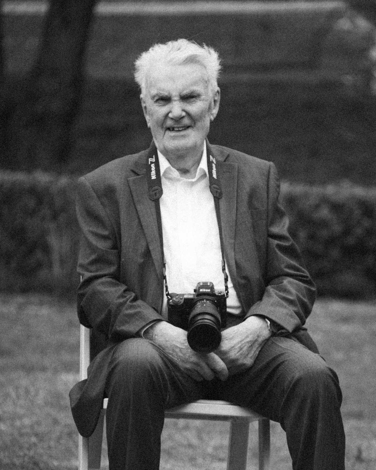 Candid moment grandfather with his camera during an outdoor wedding reception in Tanunda by Barossa Valley photographer Matt Webster