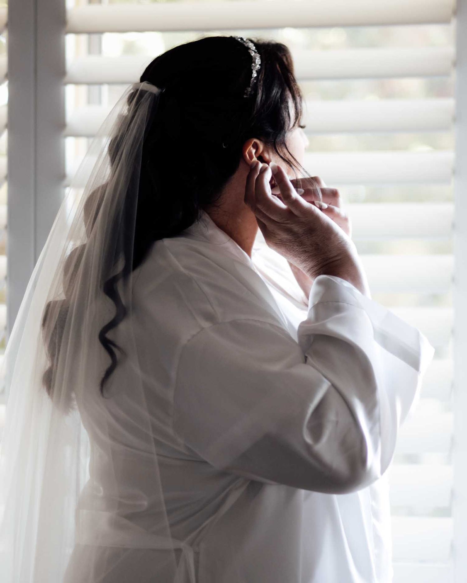 Bride putting her earrings in with natural light before her wedding in Eudunda, photographed by Barossa Valley photographer Matt Webster.