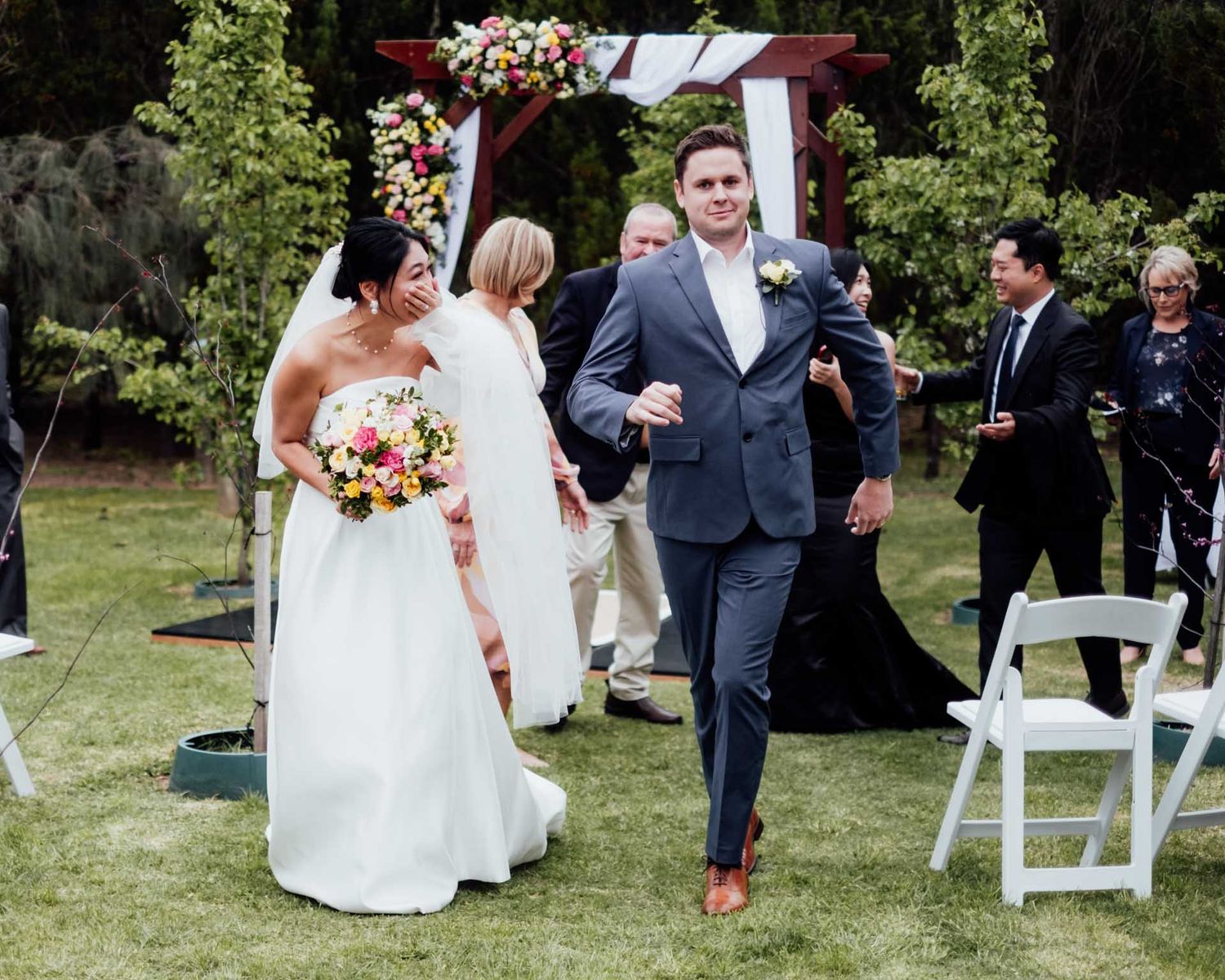 Bride and groom dancing as they walk down the isle after their outdoor wedding in Tanunda by Barossa Valley photographer Matt Webster