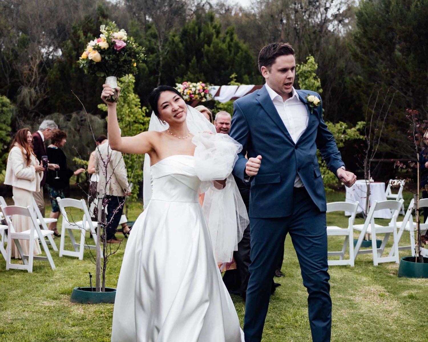 Bride and groom dancing as they walk down the isle after their outdoor wedding in Tanunda by Barossa Valley photographer Matt Webster