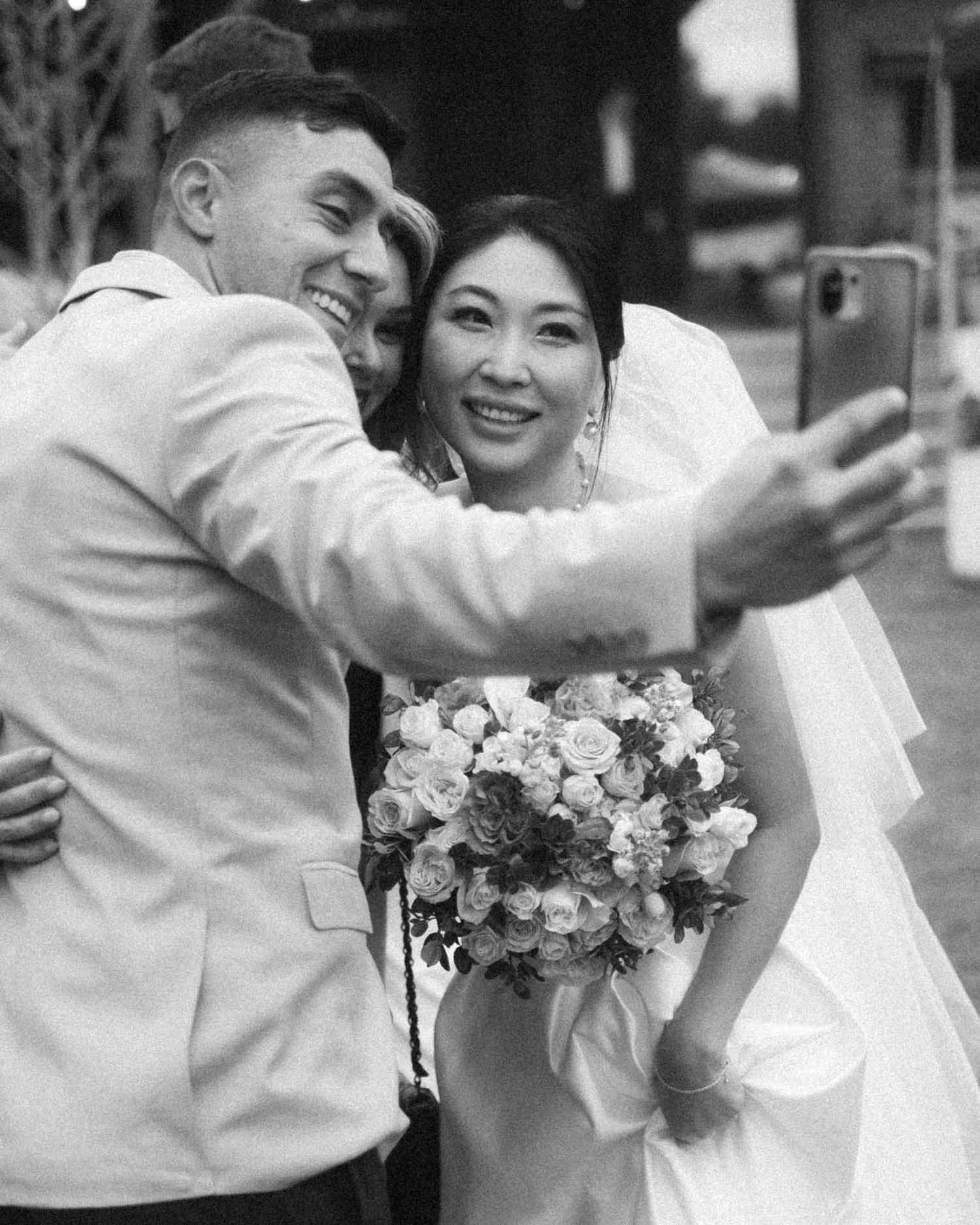Candid moment of a bride taking a selfie during an outdoor wedding reception in Tanunda by Barossa Valley photographer Matt Webster