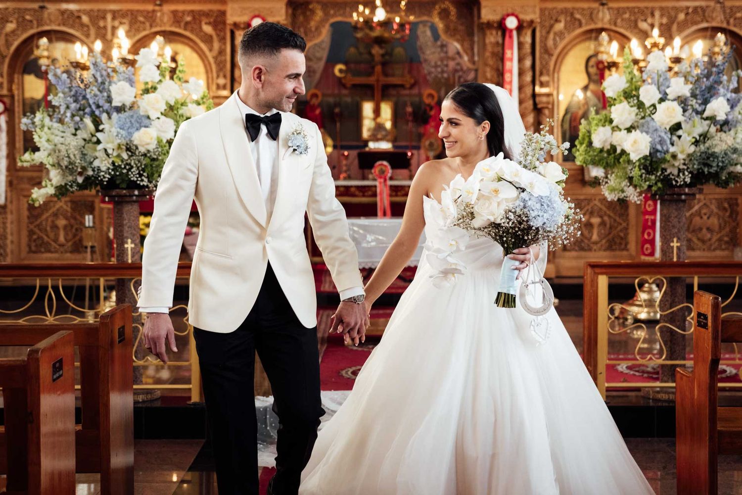 Bride and groom looking at each other while walking down the isle of St George Orthodox Church, Thebarton, captured by Matt Webster.