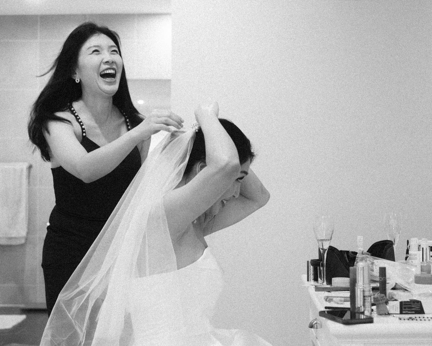 Candid moment of bridesmaid laughing while helping the bride get ready in Tanunda by Barossa Valley photographer Matt Webster