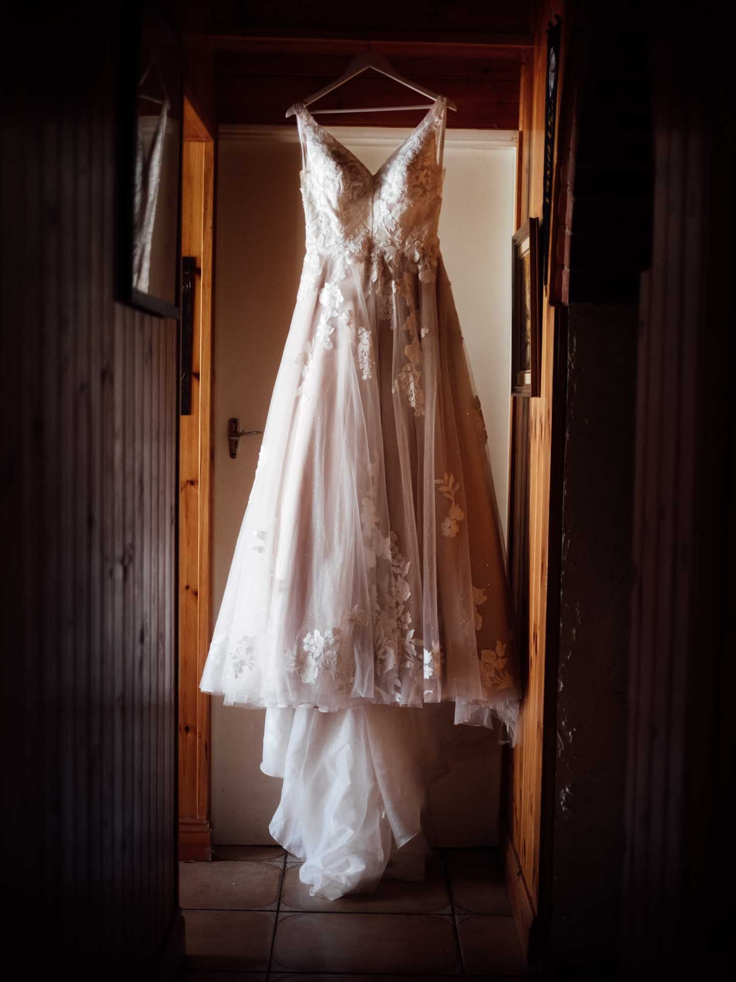 Brides wedding dress hangs in a hallway in the Adelaide Hills, photographed by Barossa Valley wedding photographer Matt Webster.