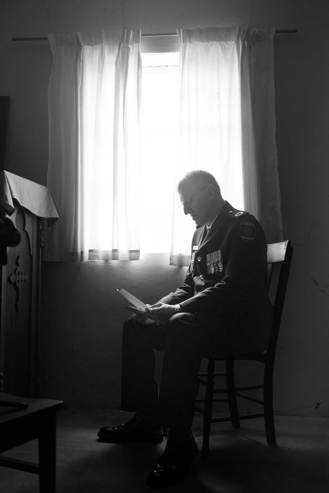 Groom reads a letter from his bride near a window, captured in black and white by Barossa Valley photographer Matt Webster.