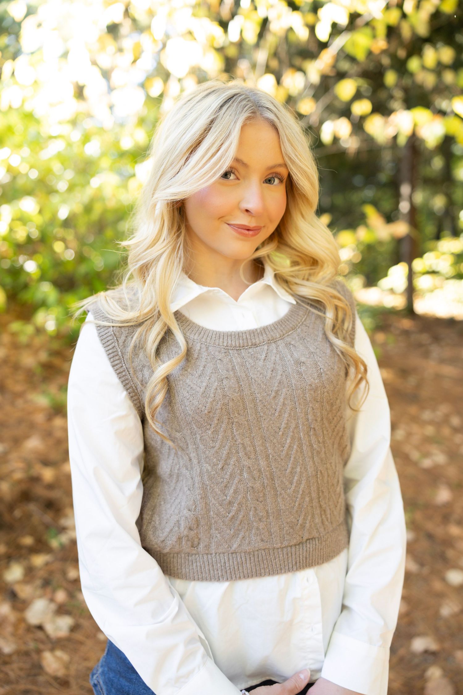 Autumn fashion portrait featuring cable knit vest layered over crisp white collared shirt.
