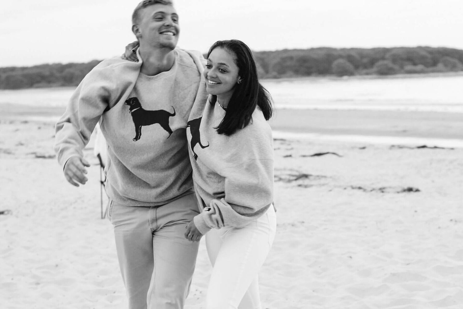 Black and white photo of a joyful beach engagement session.