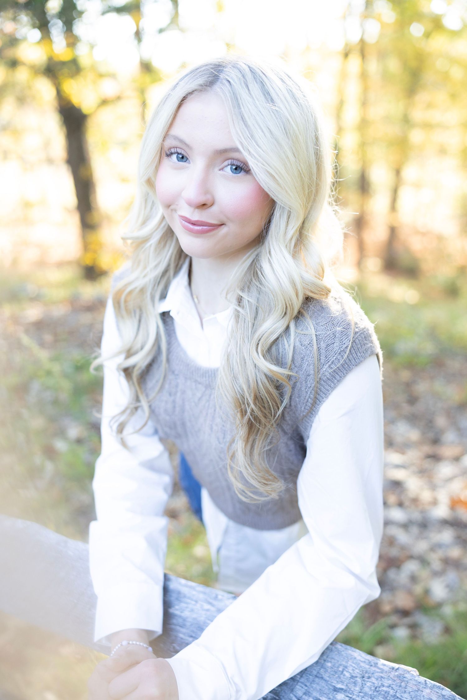 Outdoor portrait of a person wearing a gray knit vest over white collared shirt.