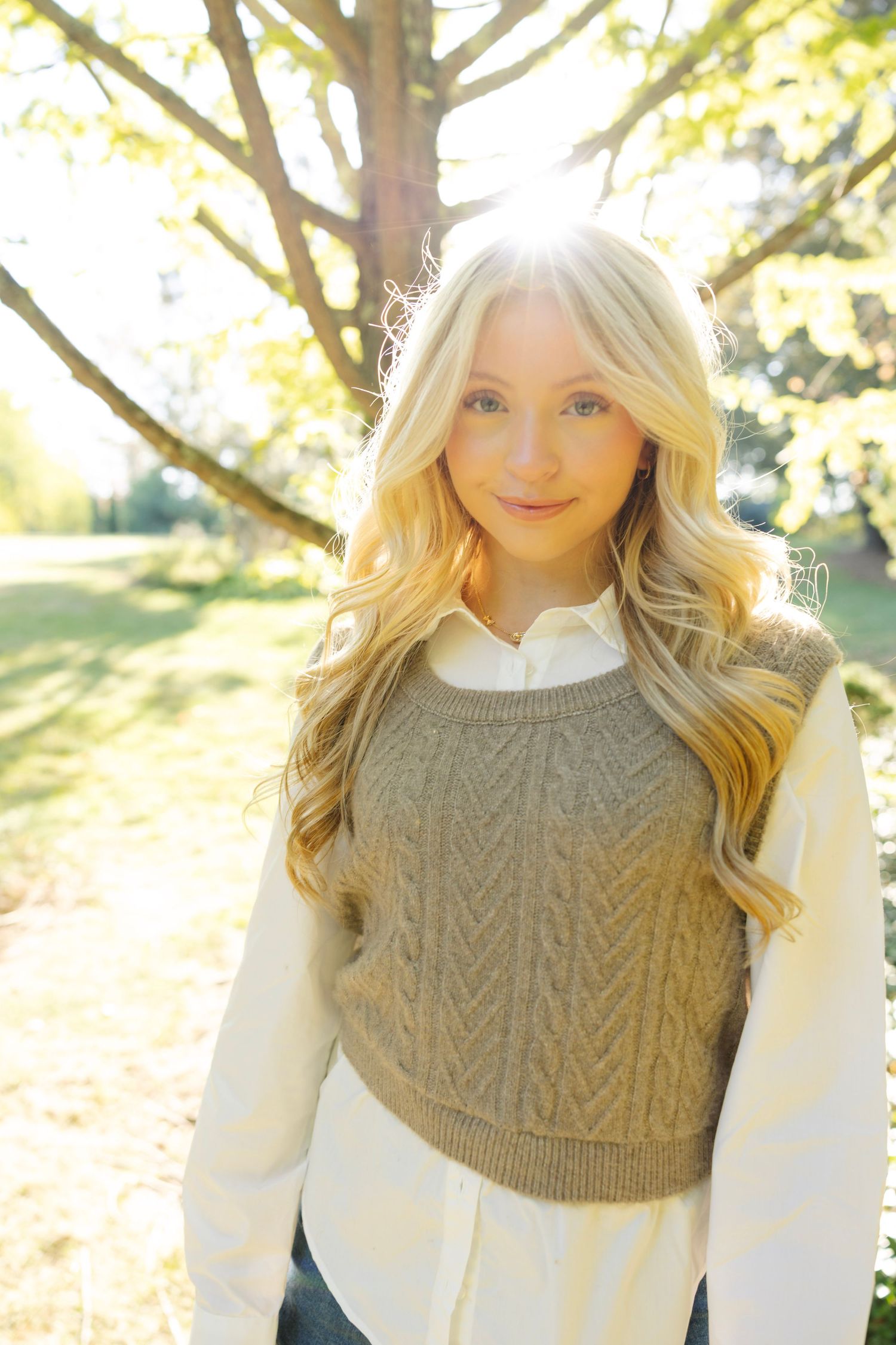 Autumn outdoor portrait showcasing a tan cable knit vest over white collared shirt with soft natural lighting.