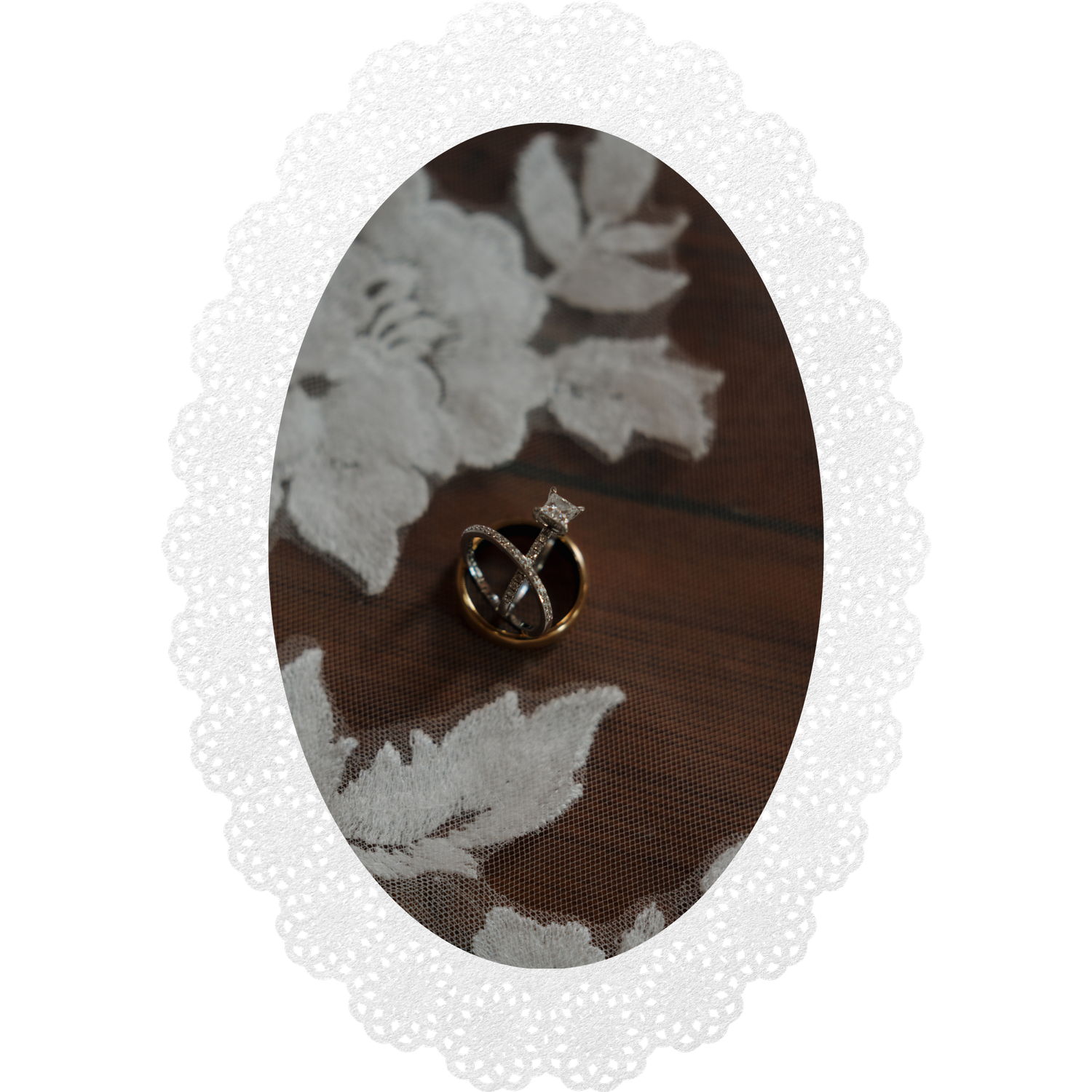 Small gold decorative pin resting on a white lace doily atop a dark wooden surface.