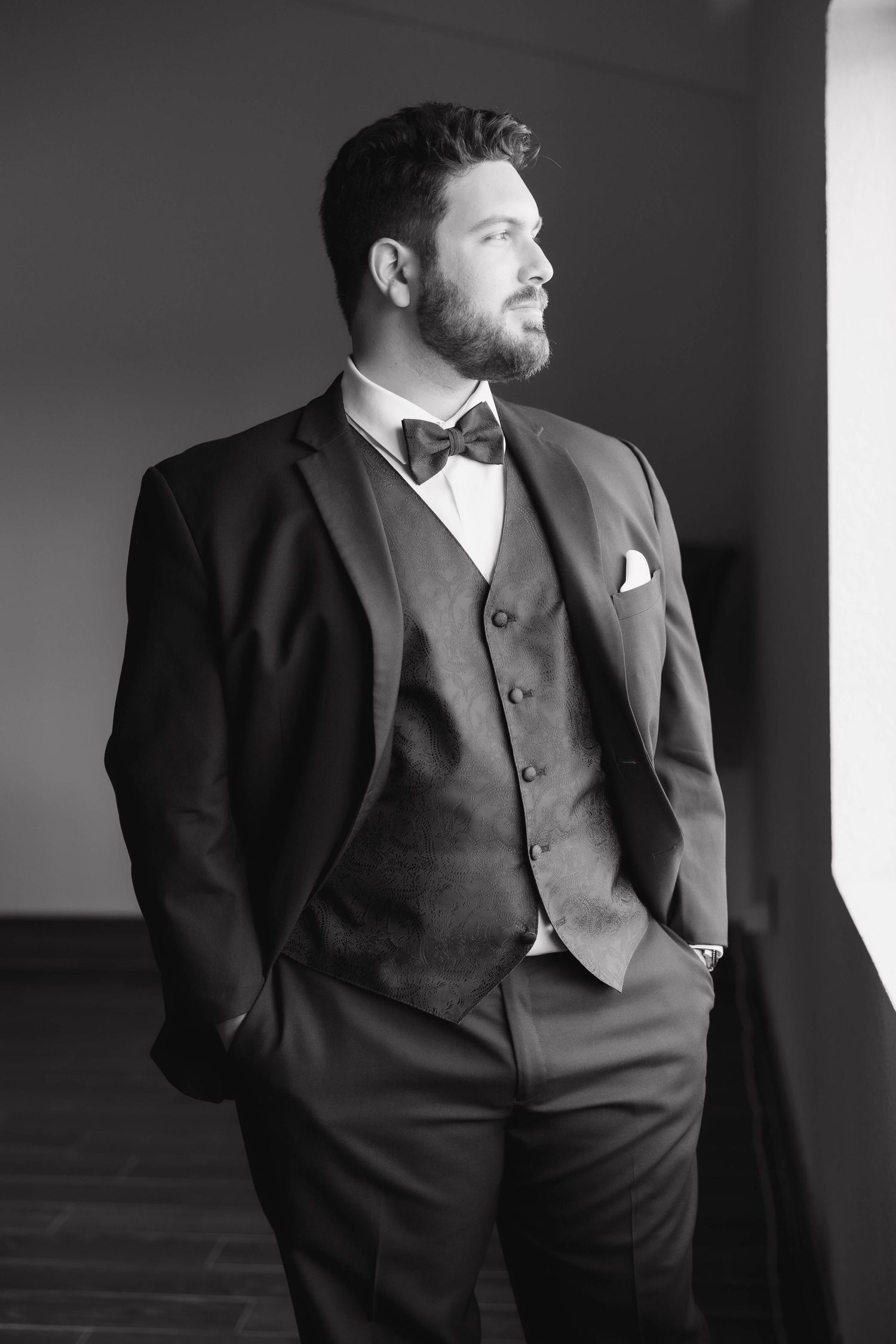 Black and white portrait series showing a man in formal attire posing in different angles against a light background.