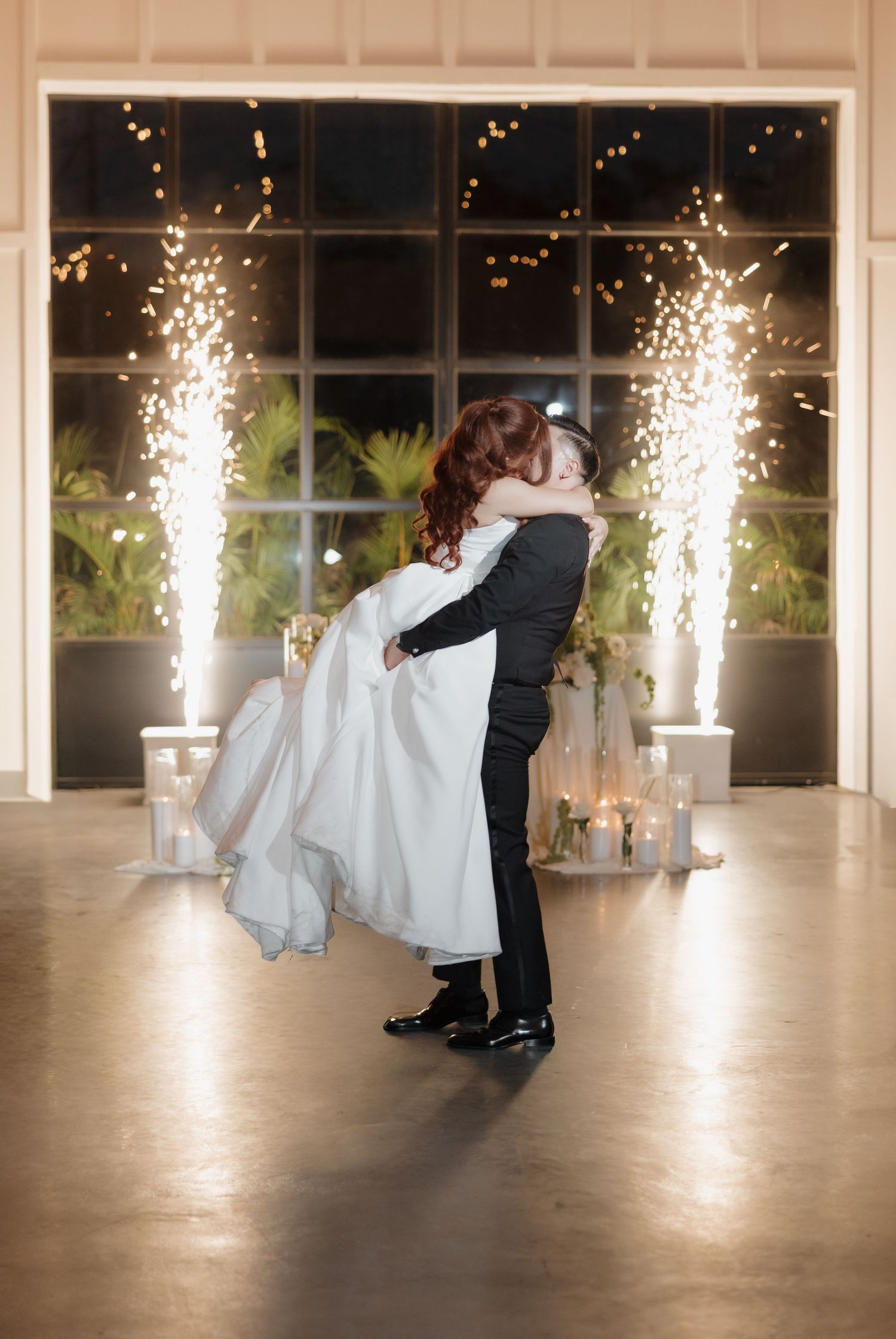 A romantic wedding dance sequence showing a dip move with sparklers creating a magical backdrop in an elegant venue.