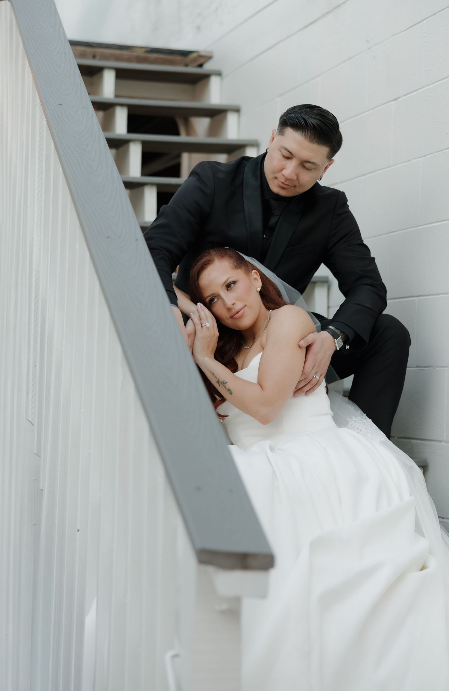 A romantic wedding couple poses together on white stairs in a series of intimate dip poses.
