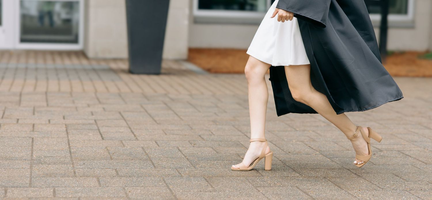 Cropped view of formal wedding attire and shoes on outdoor stone pavement.