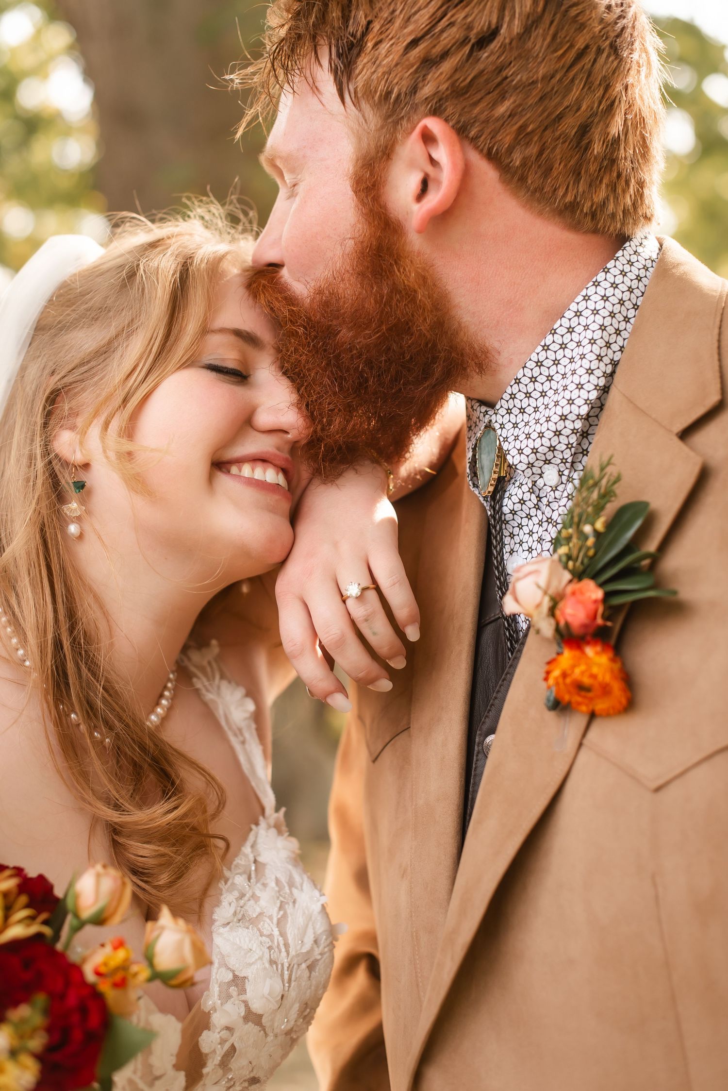 Intimate wedding moment captured in warm sunlight with autumn-colored boutonniere.
