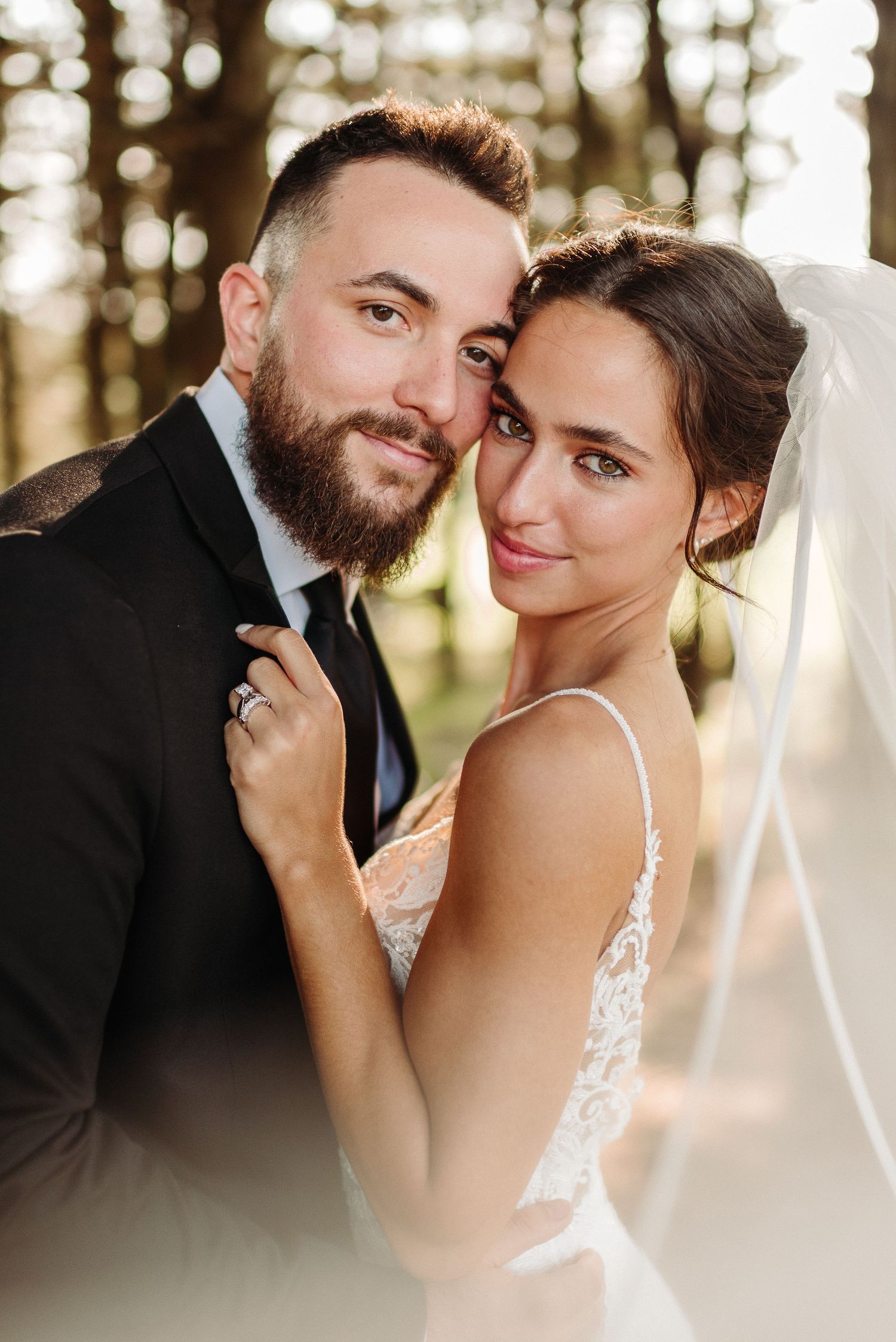 A romantic wedding portrait series showing tender moments between newlyweds in a sunlit forest setting in Berks County PA.