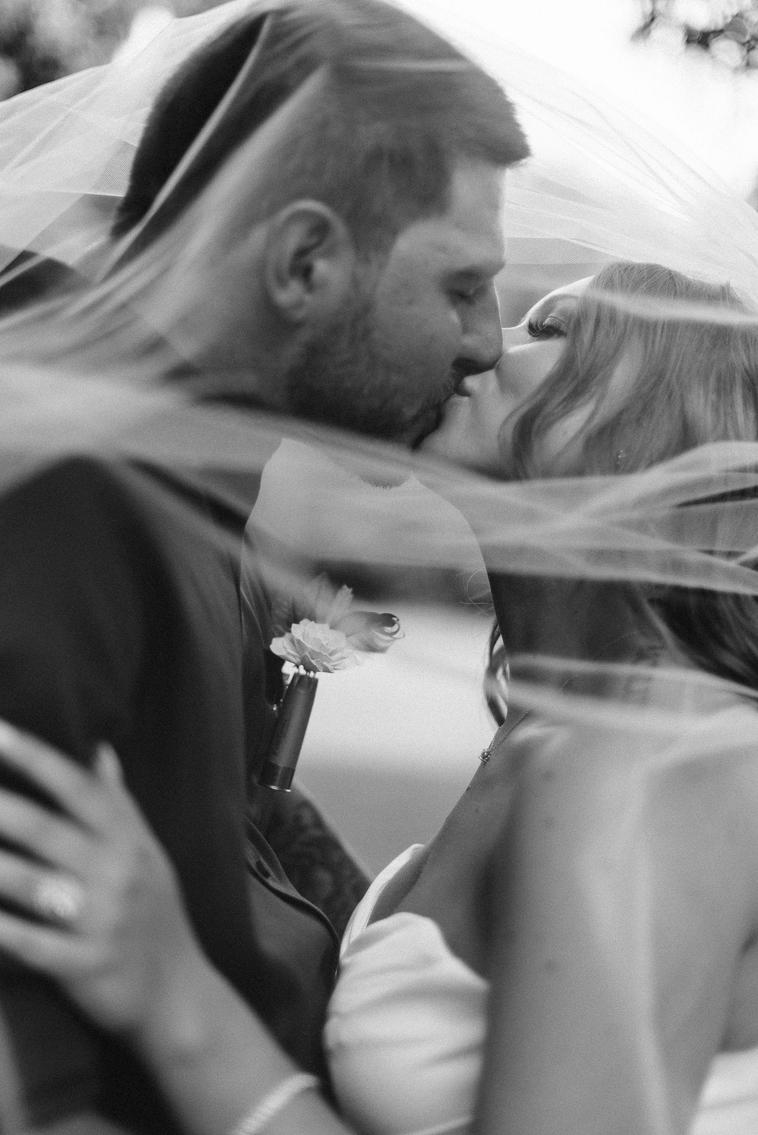 A romantic black and white wedding photo sequence showing a couple sharing a kiss under a flowing veil in Berks County PA.