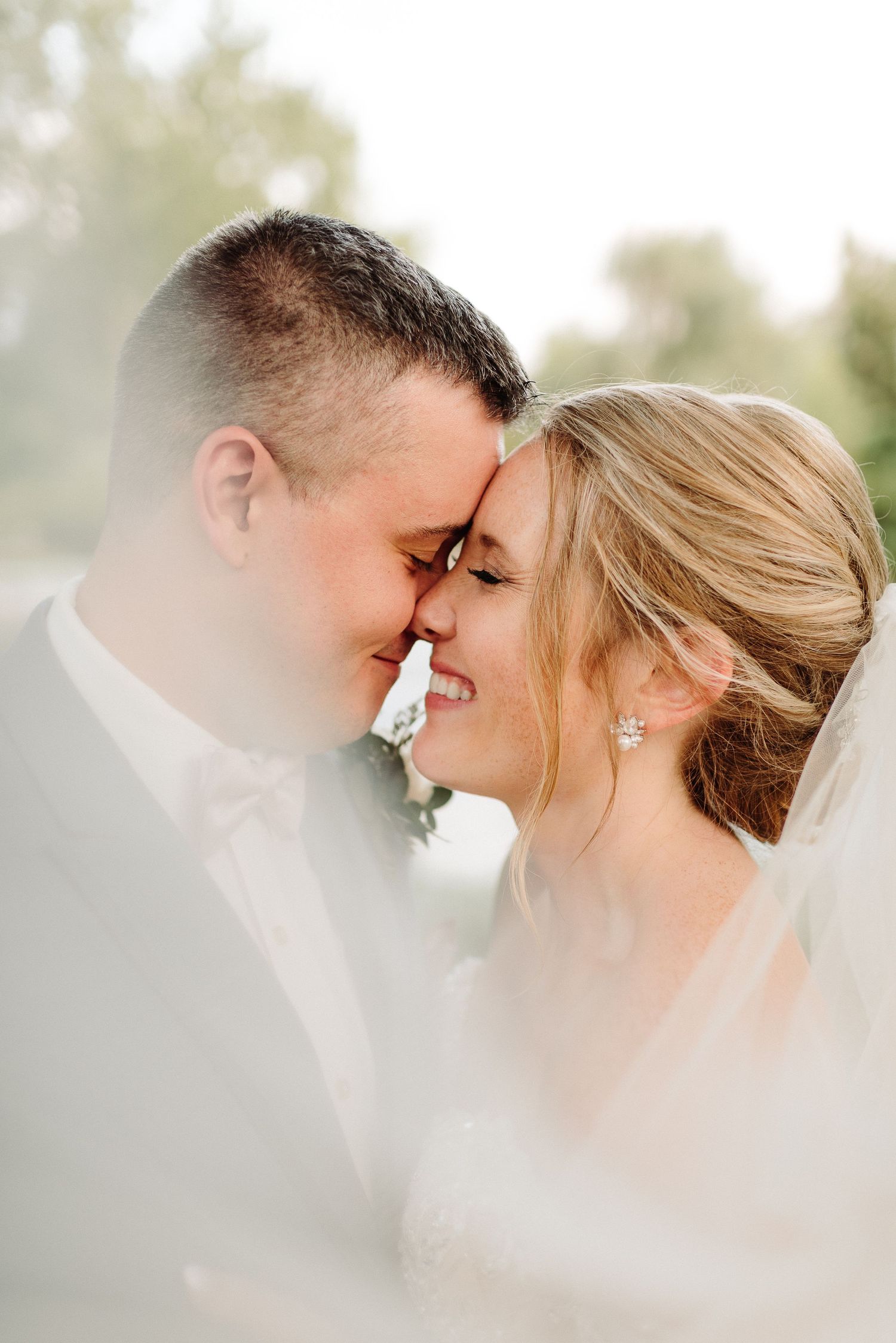 A romantic close-up portrait of a couple sharing an intimate moment in soft, dreamy lighting.