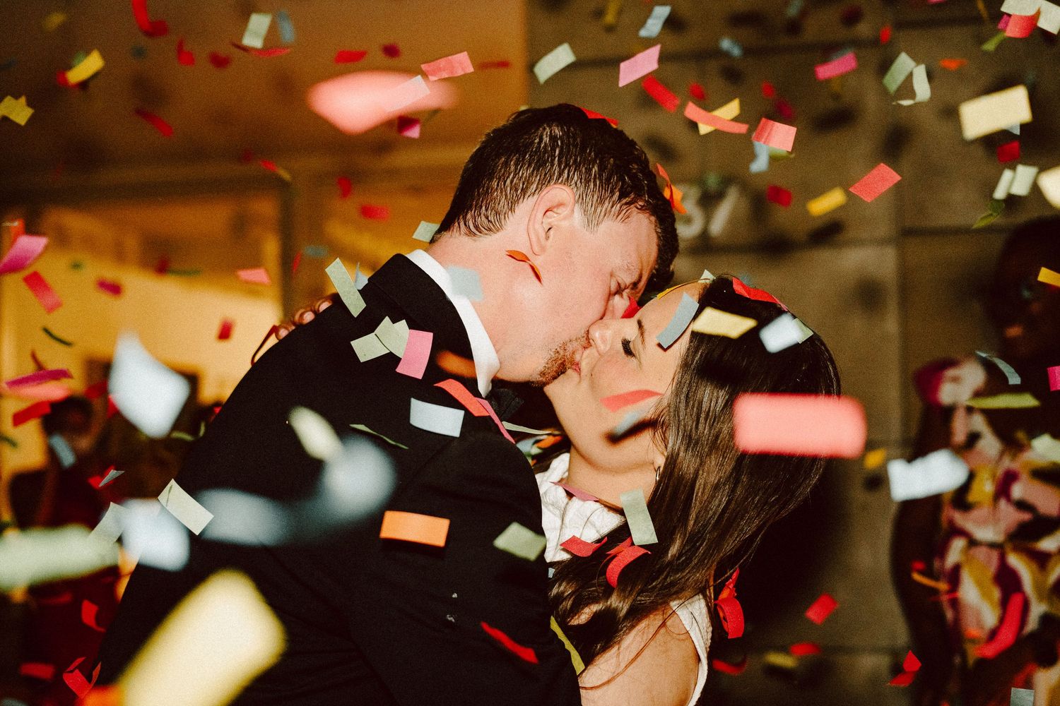 A romantic couple shares a kiss under falling red and white confetti during a celebration in Lancaster, PA.