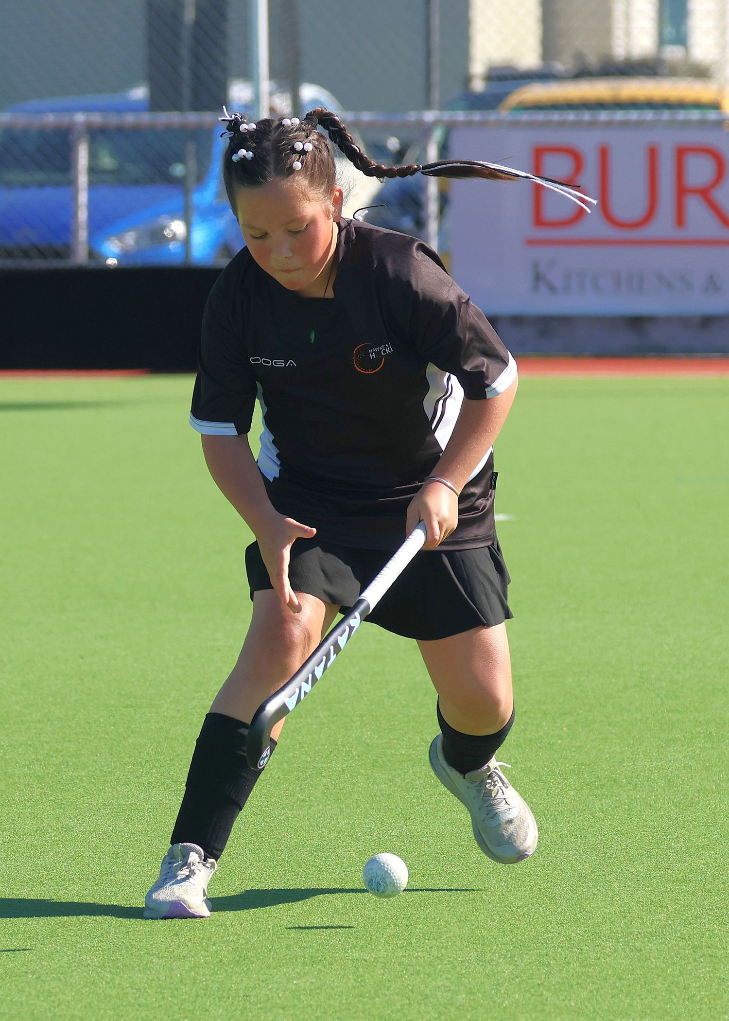 U14 Hawke's Bay player sidestepping out of trouble while dribbling the hockey ball.