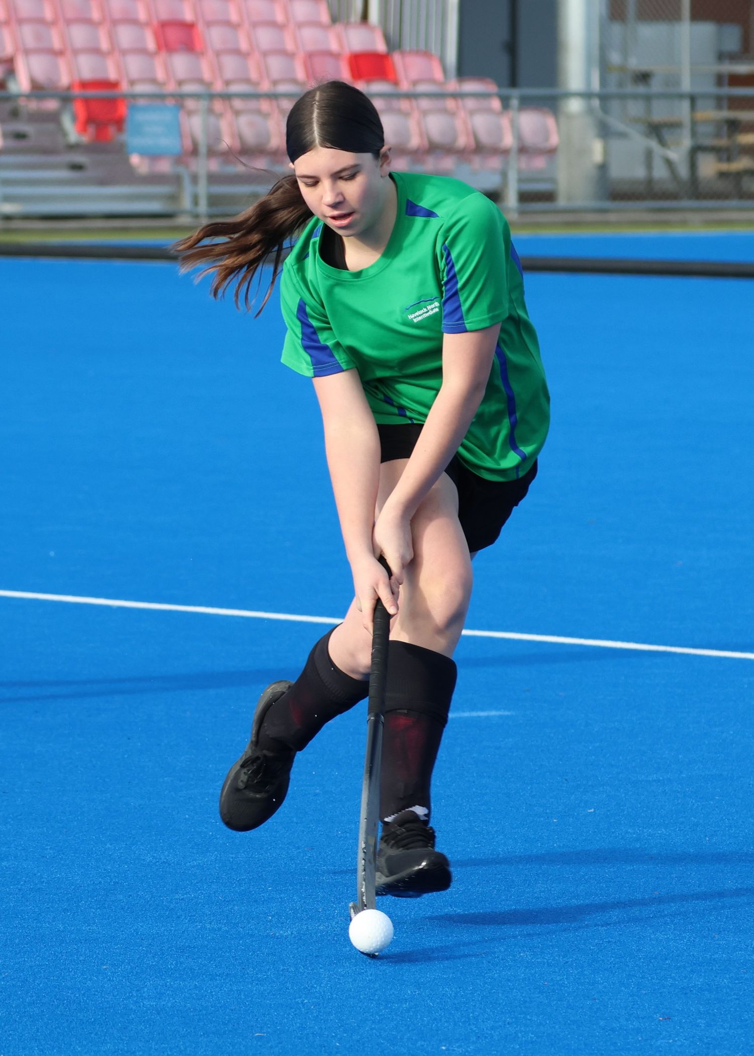Havelock North Intermediate School female hockey player dribbling the hockey ball.