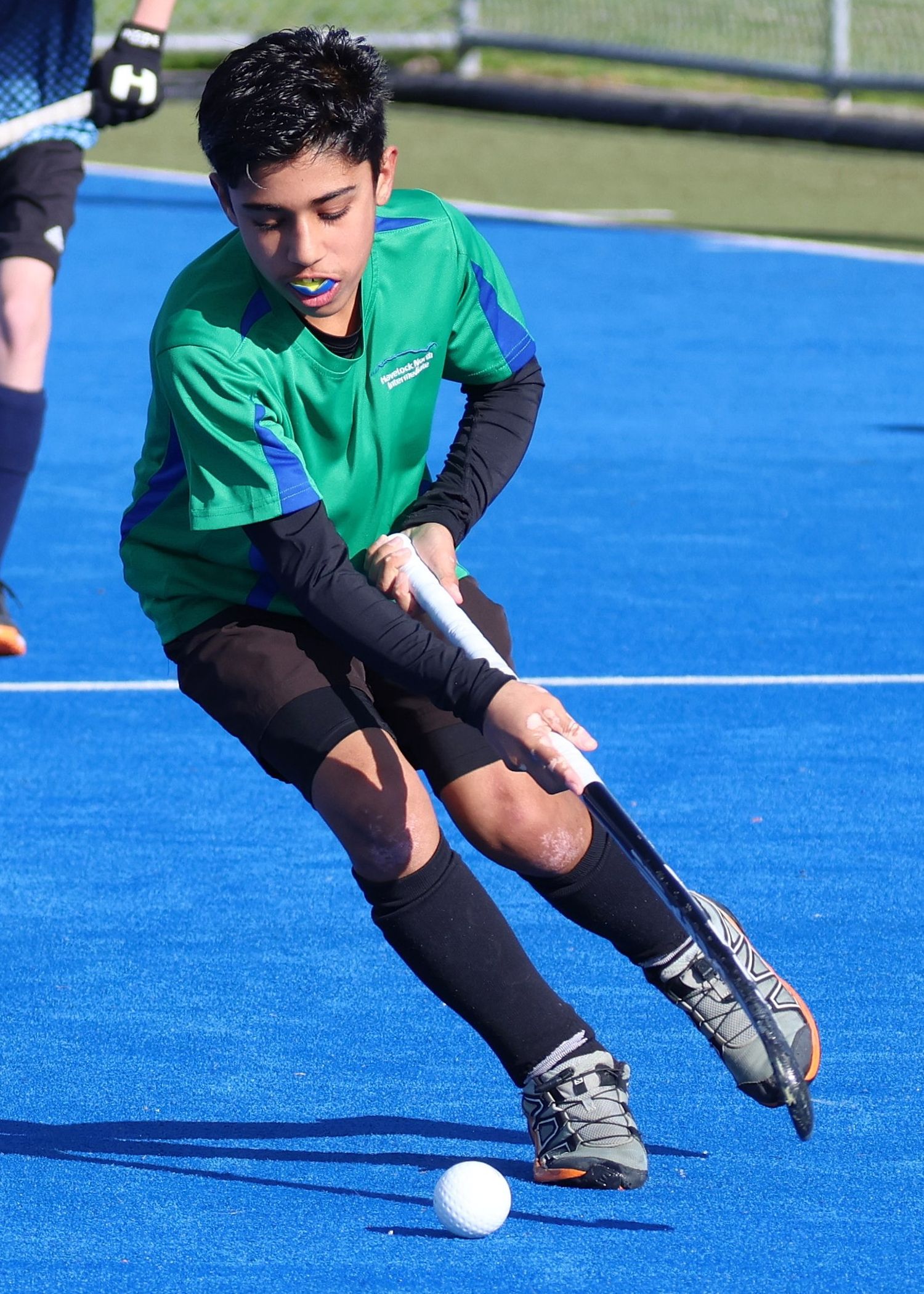 Havelock North Intermediate School male hockey player making dynamic direction change with his backhand.