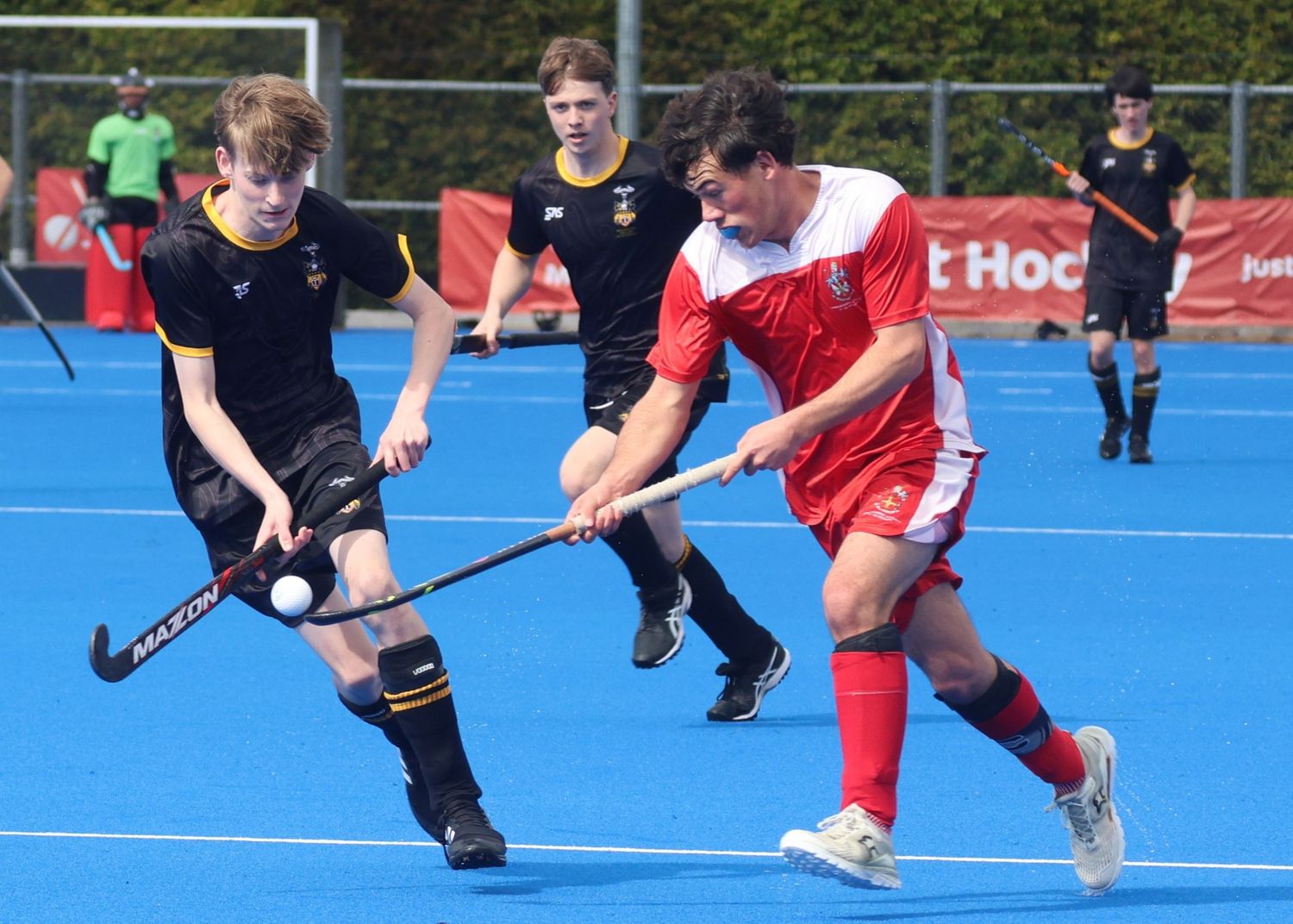 Lindisfarne College New Zealand Secondary Schools player at Rankin Cup, carrying the hockey ball away from the defender.