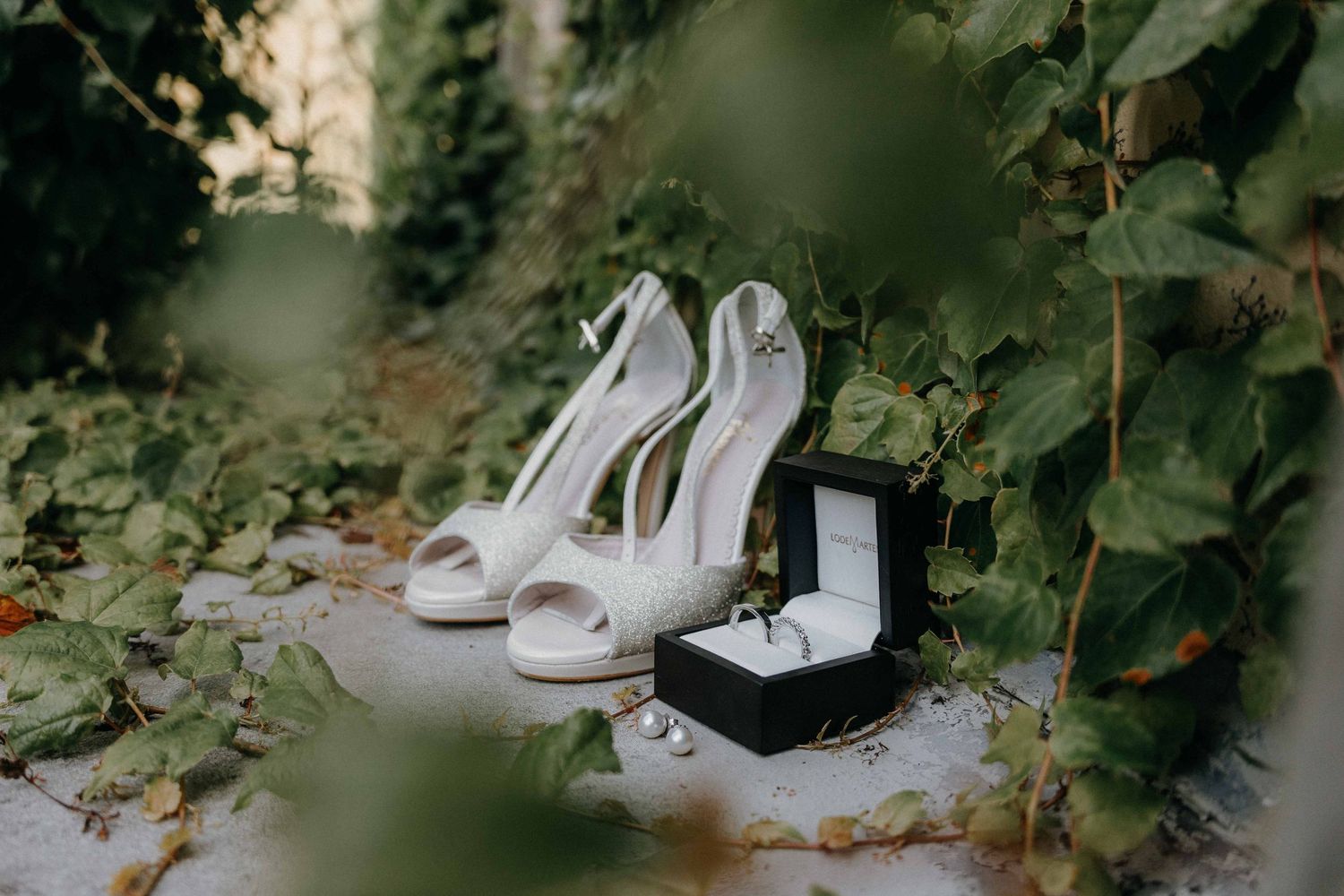 detail foto schoenen en ringen en oorbellen huwelijk in Maastricht van huwelijksfotograaf en videograaf based in Antwerpen.
