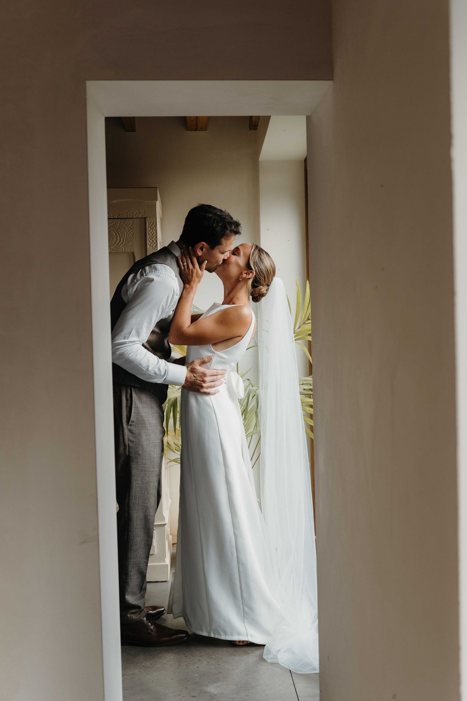 foto bruid en bruidegom kus first look thuis natuurlijk licht liefde van huwelijksfotograaf en videograaf based in Antwerpen.