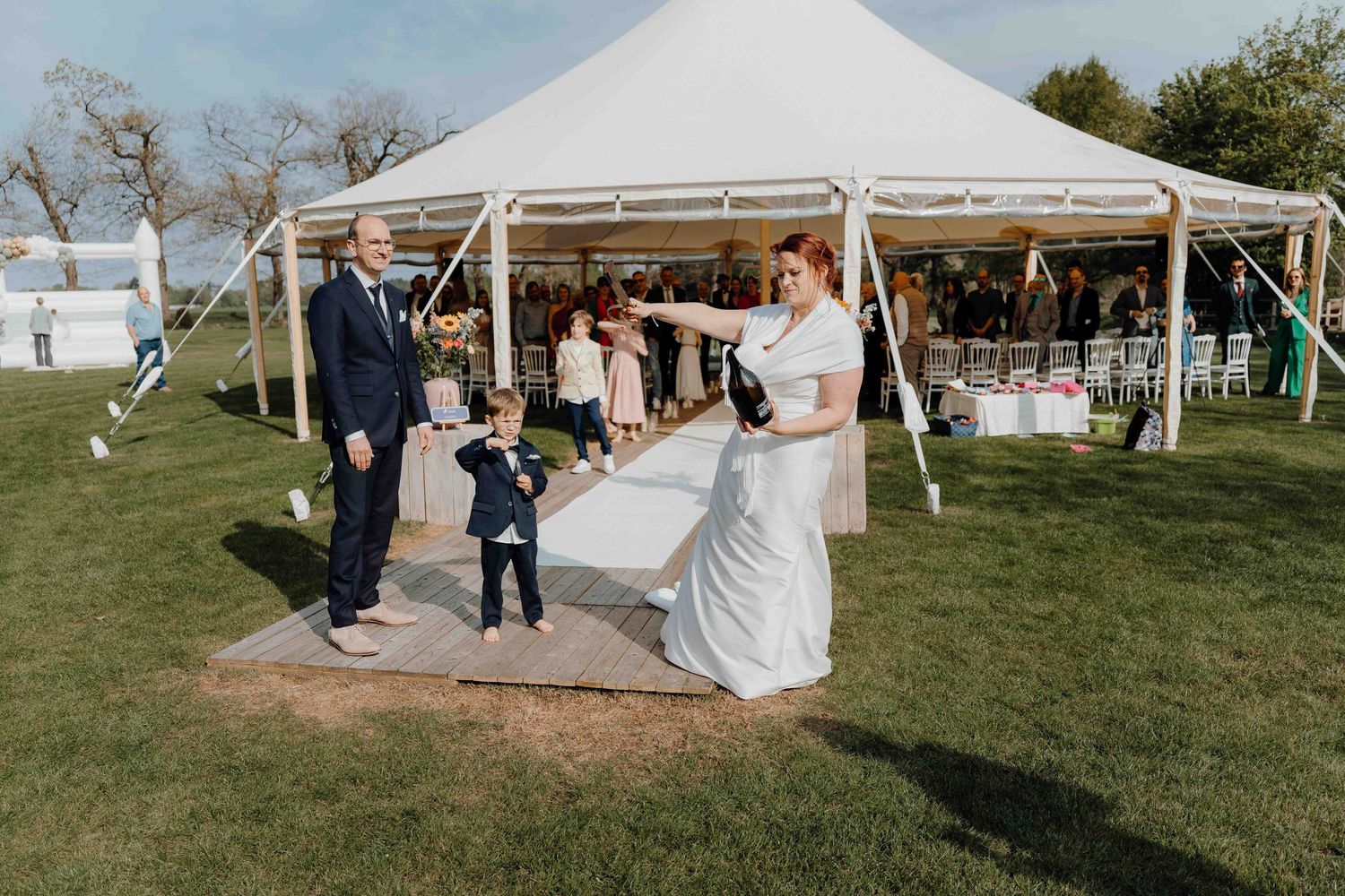 koppel dat fles champagne openknalt aan tent van boeretang in Dessel van huwelijksfotograaf en videograaf based in Antwerpen.