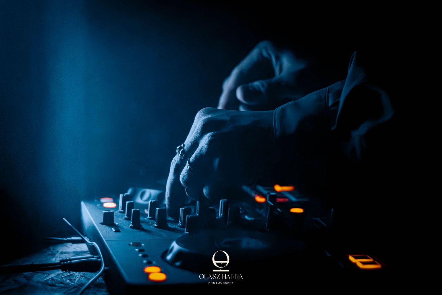 DJ kezek zenét kevernek egy sötét klubban