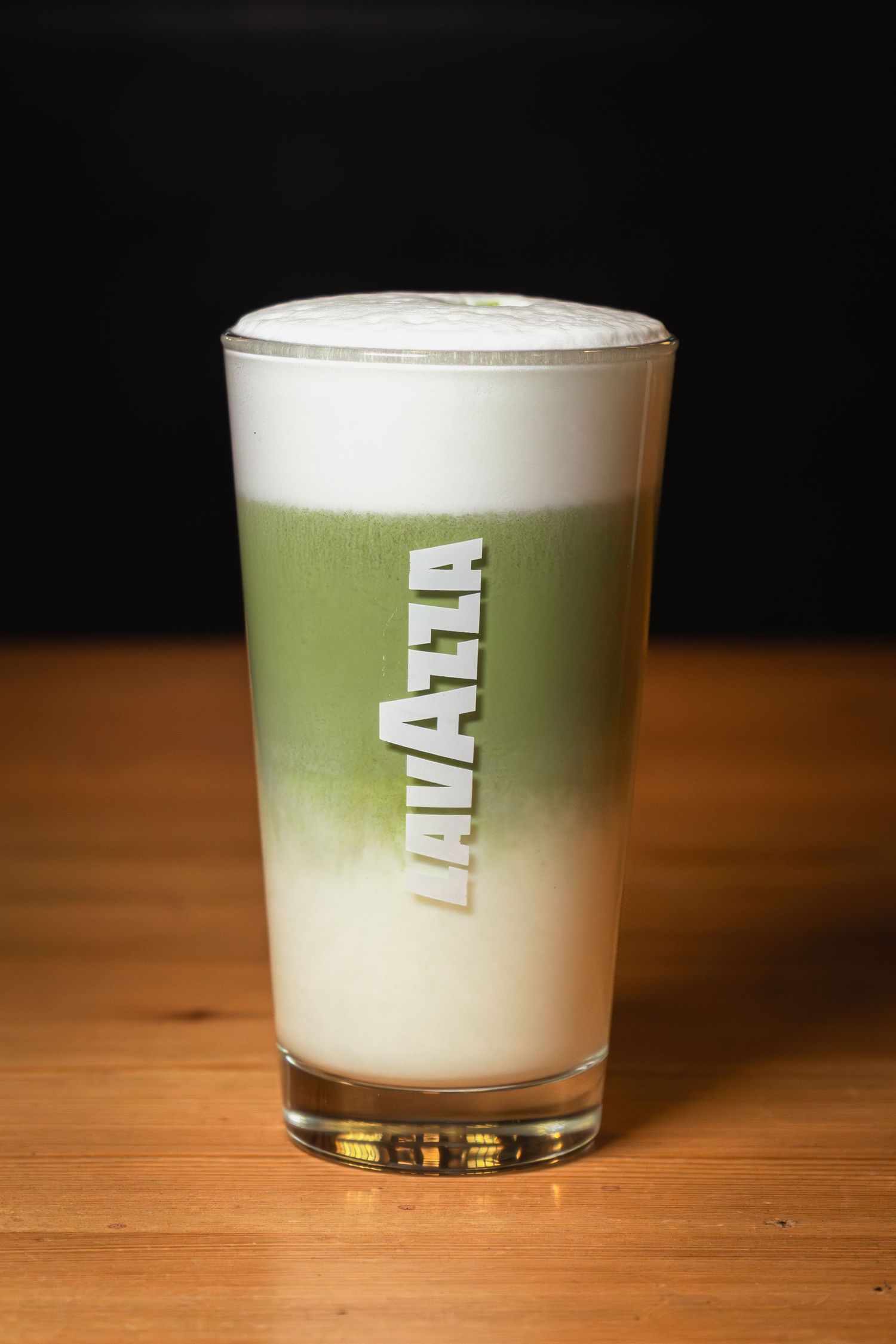 matcha latte rétegezve egy pohárban habos tejjel