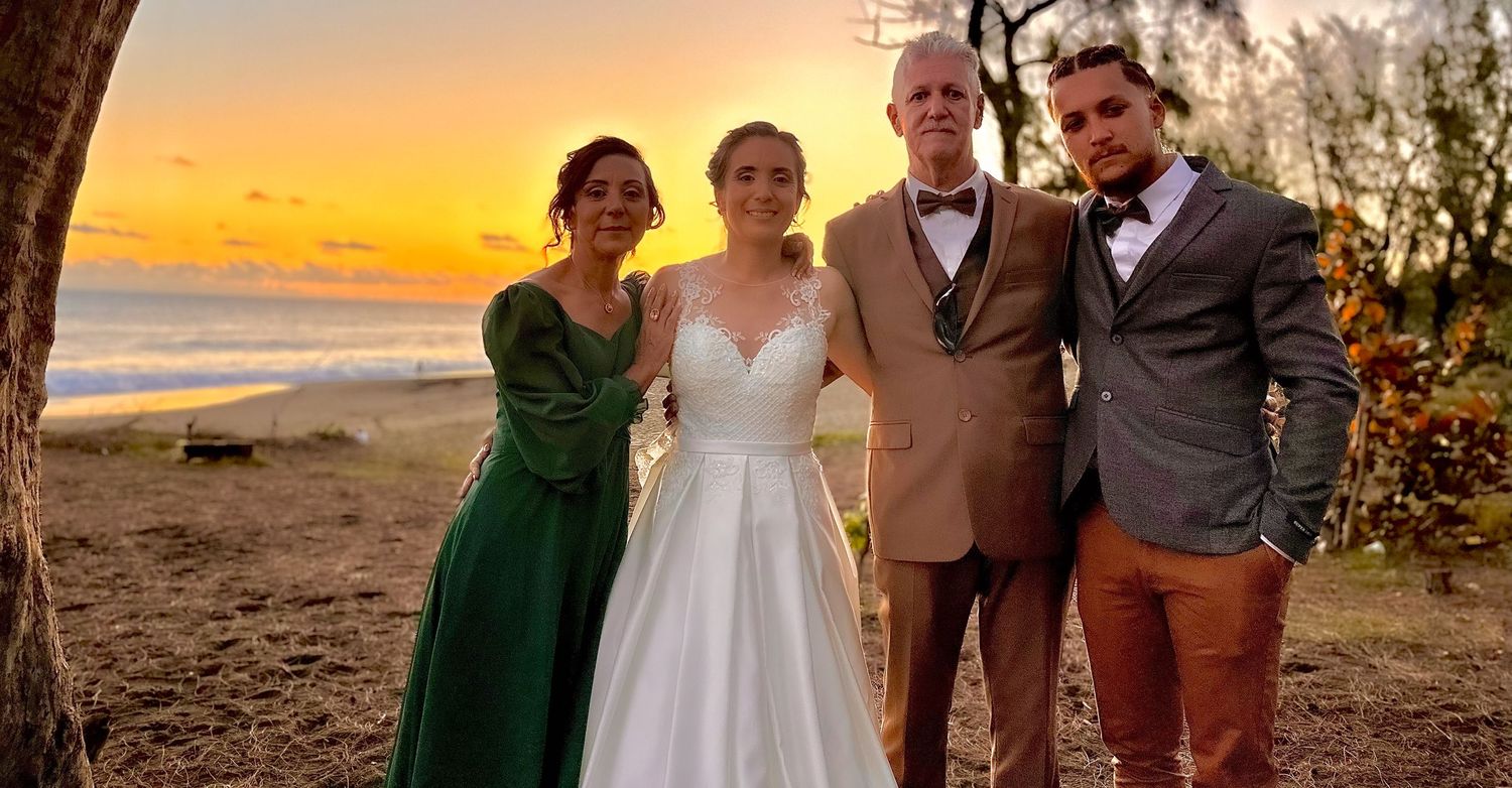 Photographie de famille lors d’un mariage au coucher du soleil.