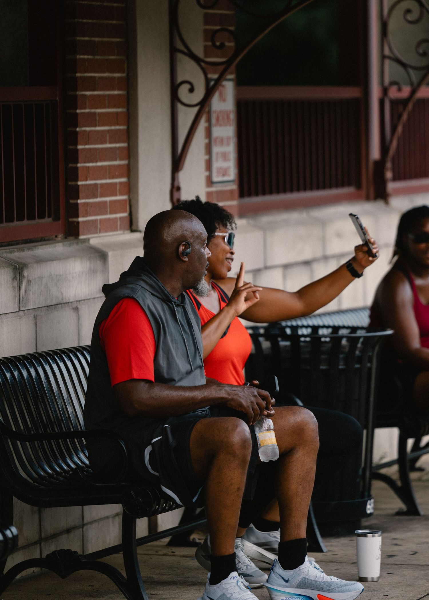 Two people sitting on a bench taking a selfie during a Krimson Sole running club event.