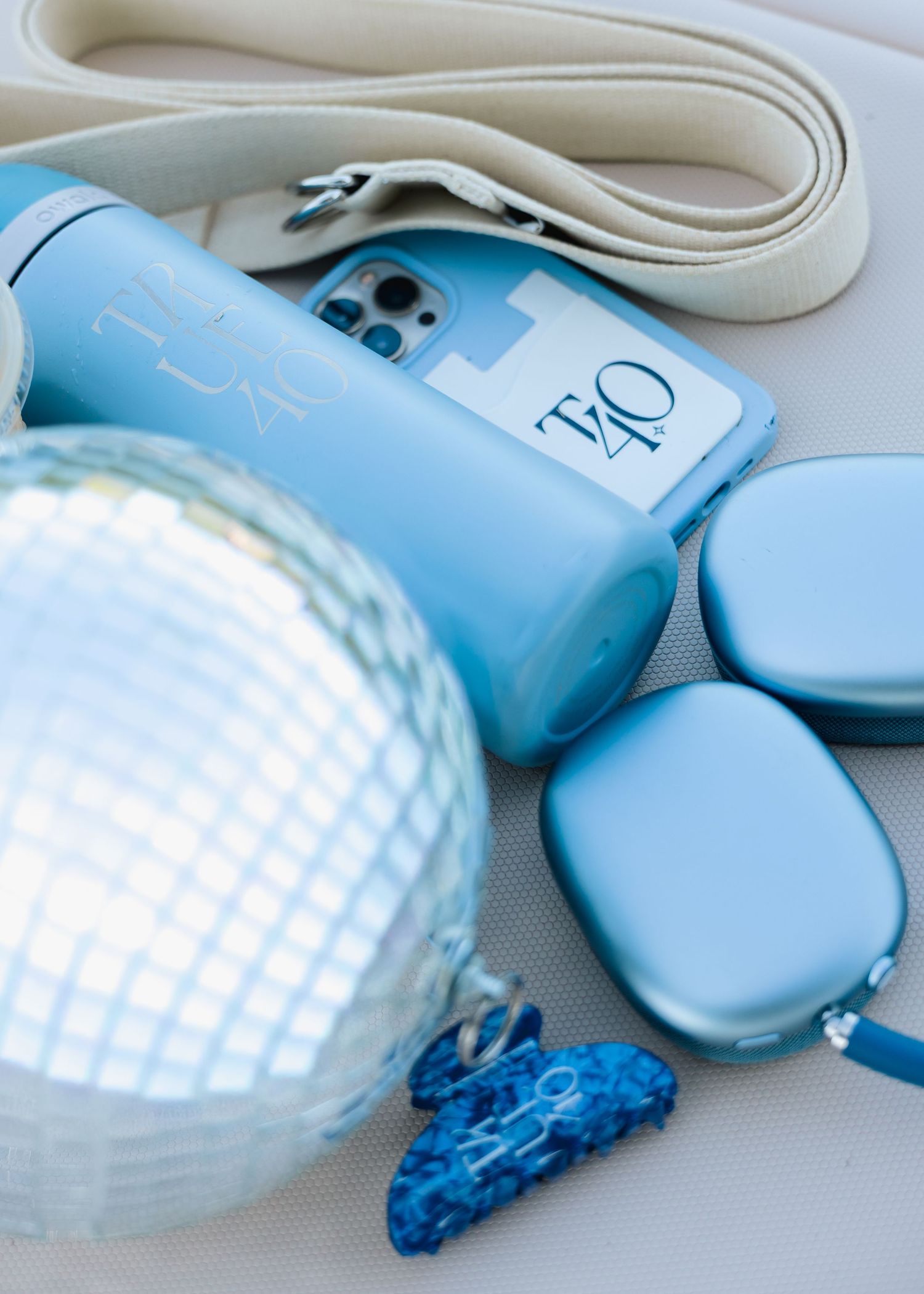 Blue fitness accessories including water bottle, phone case, headphones, and disco ball on mat.