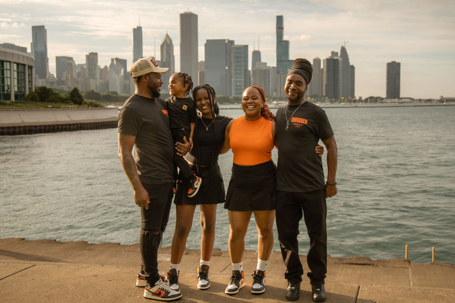 Group of four friends posing by Chicago skyline waterfront on a sunny day.