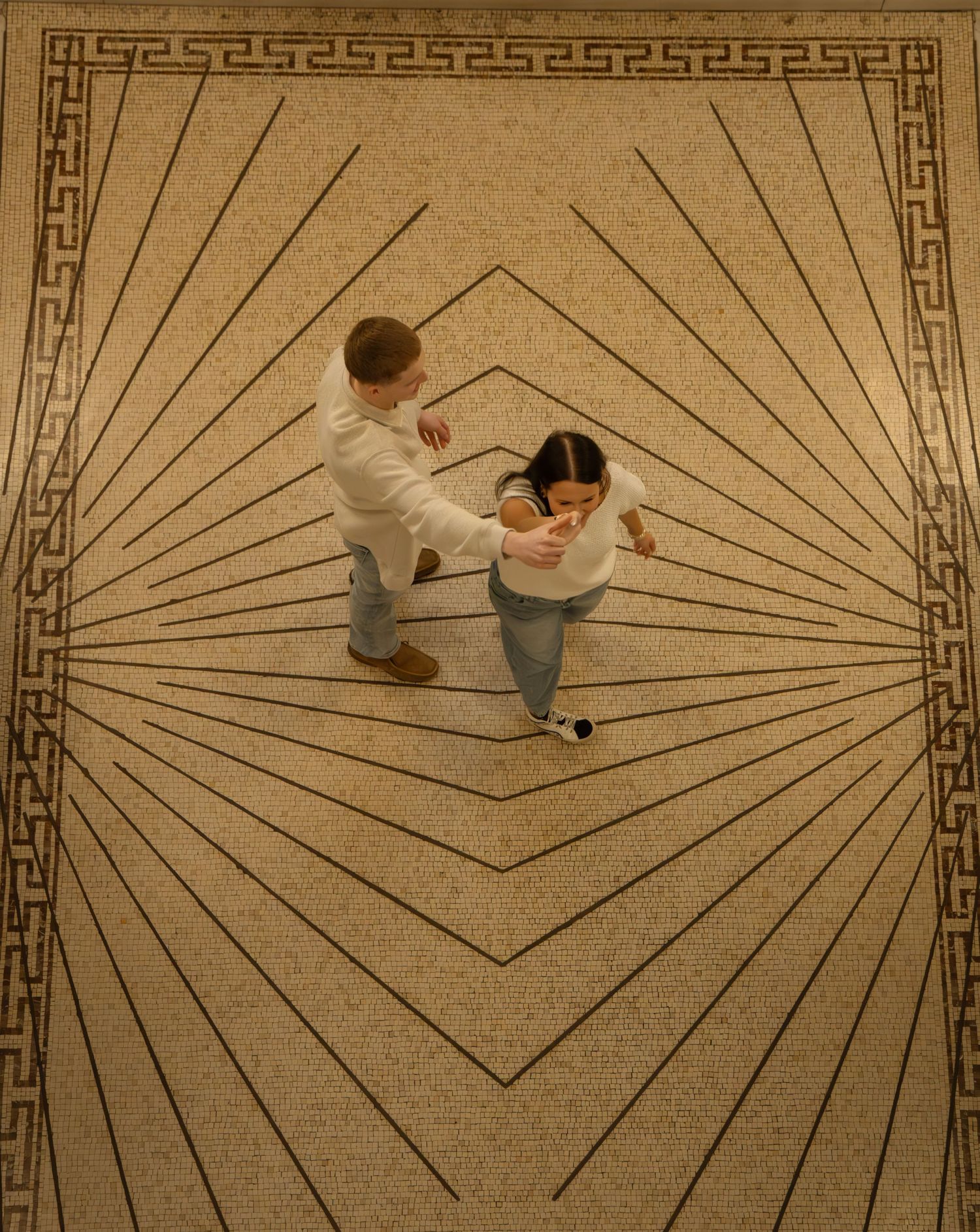 Aerial view of couple dancing on decorative geometric patterned floor with Art Deco design.